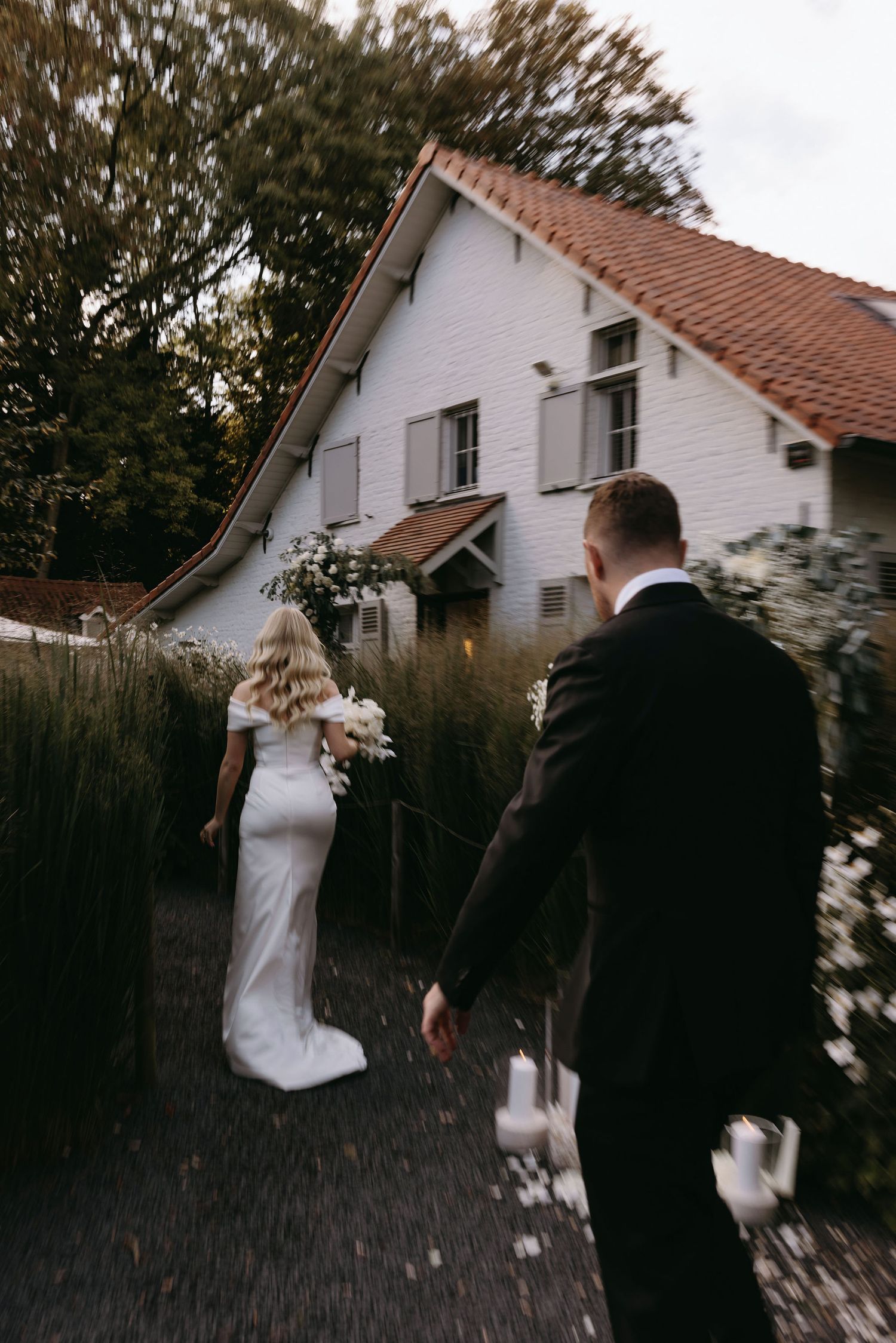 Series of motion shots showing couple dancing and twirling in front of a white house at dusk.