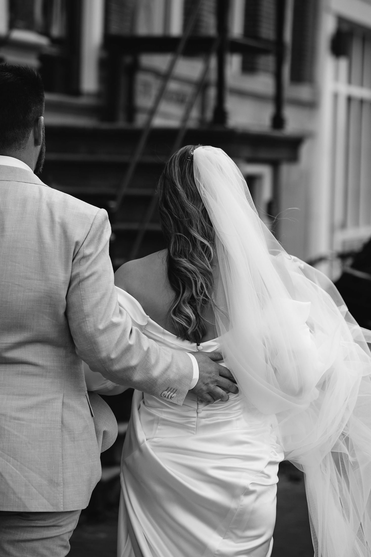 Intimate black and white wedding photography sequence showing couple in white suit and dress dancing together.