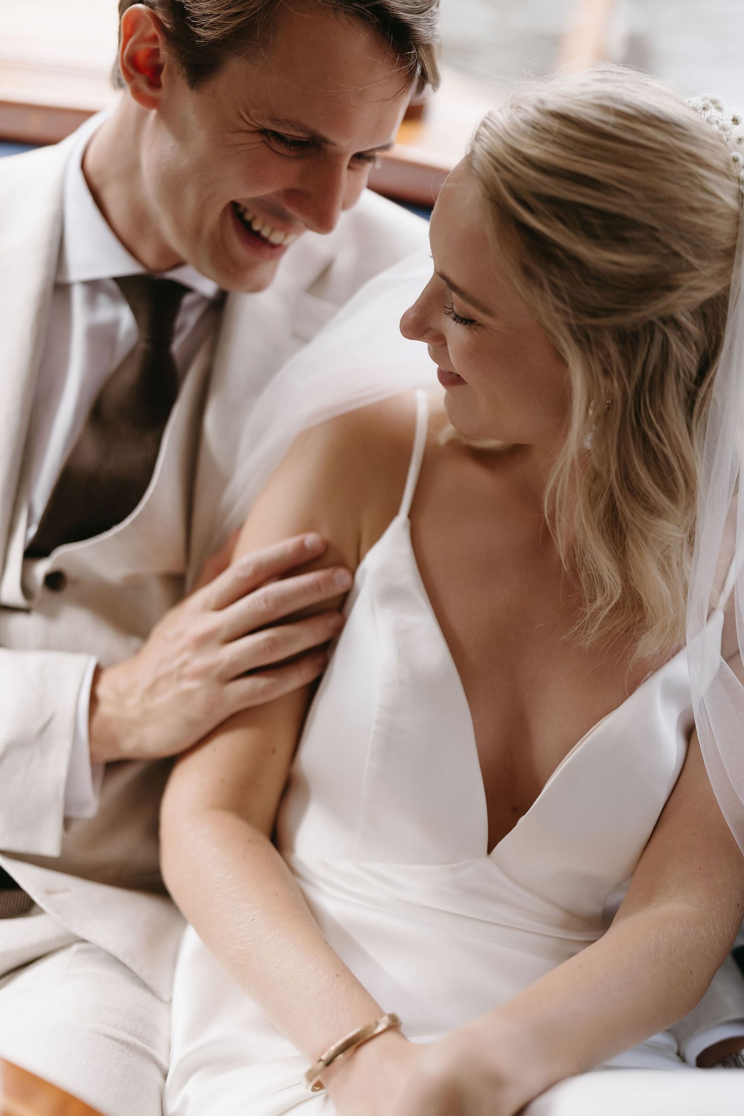 Two people share tender moments while dressed in white formal attire.