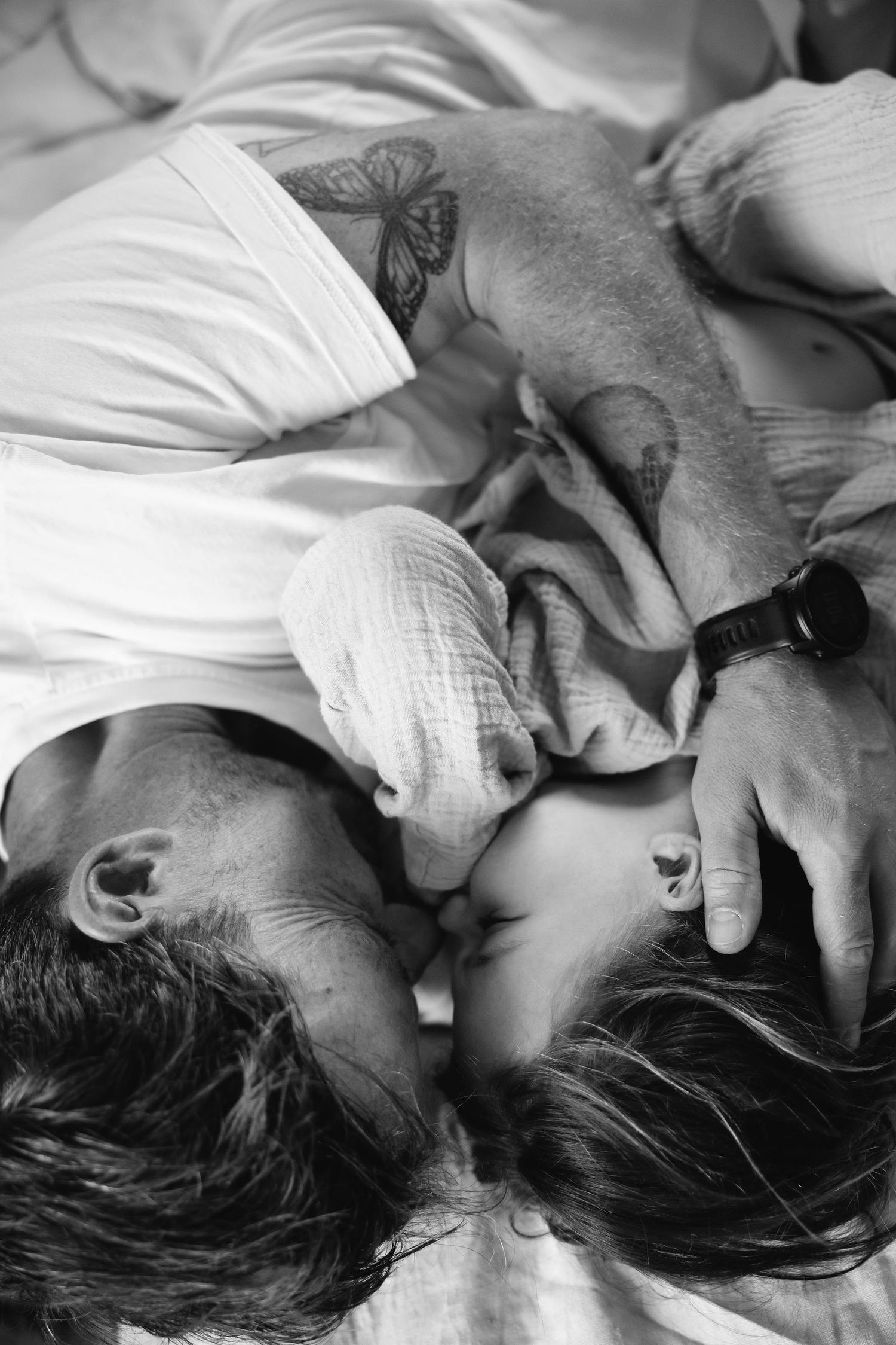 Black and white sequence showing tender moments on soft white bedding.