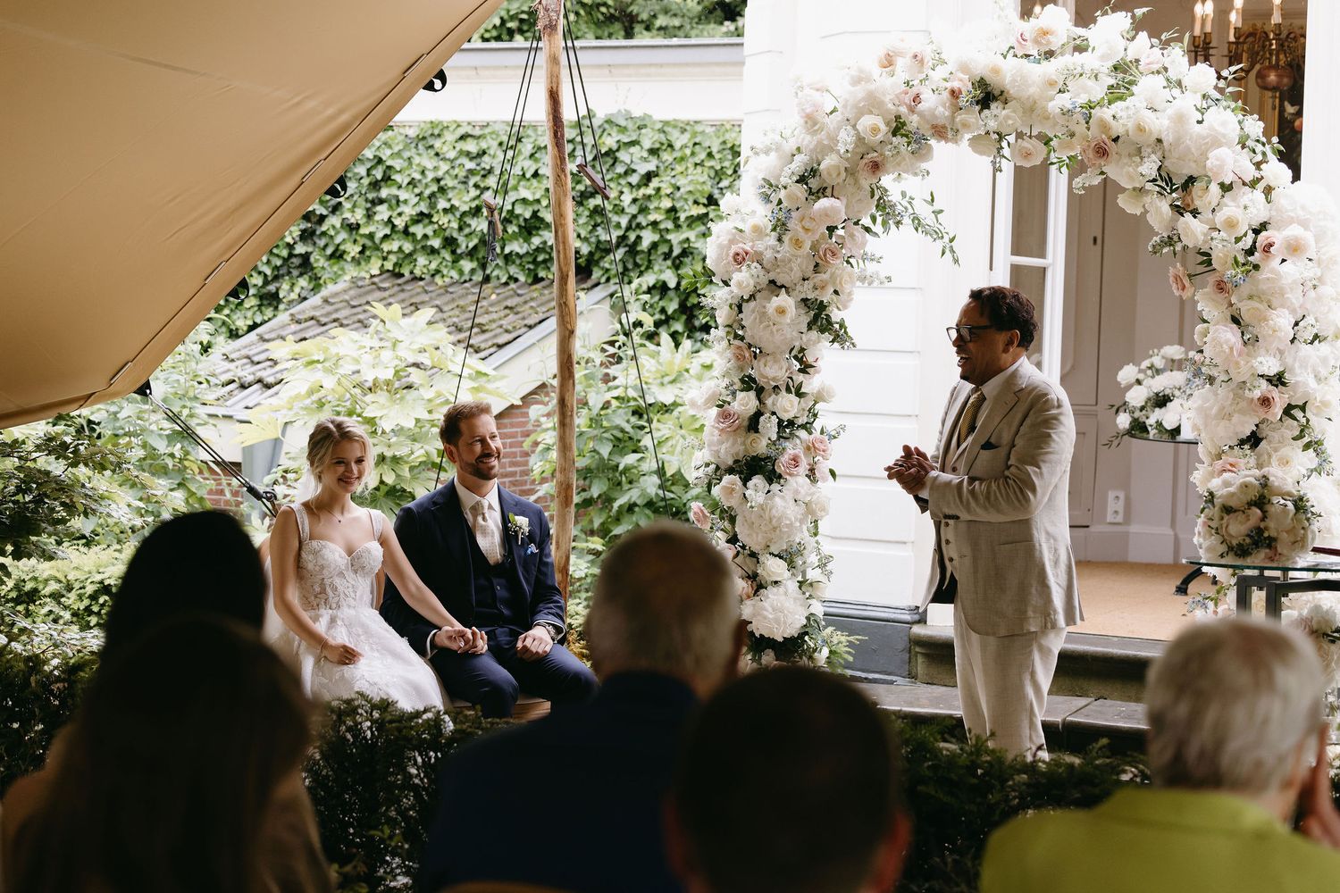 Outdoor wedding ceremony setup with floral arrangements and white decorations.