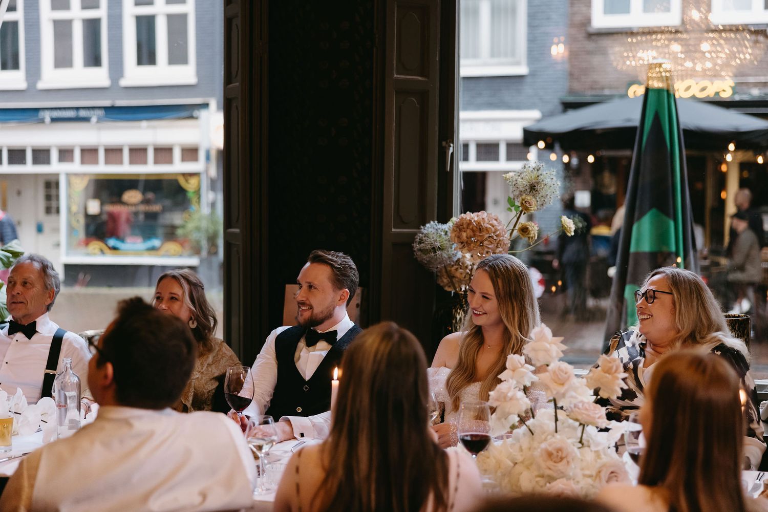 Wedding reception scene with guests seated at decorated tables enjoying the celebration.