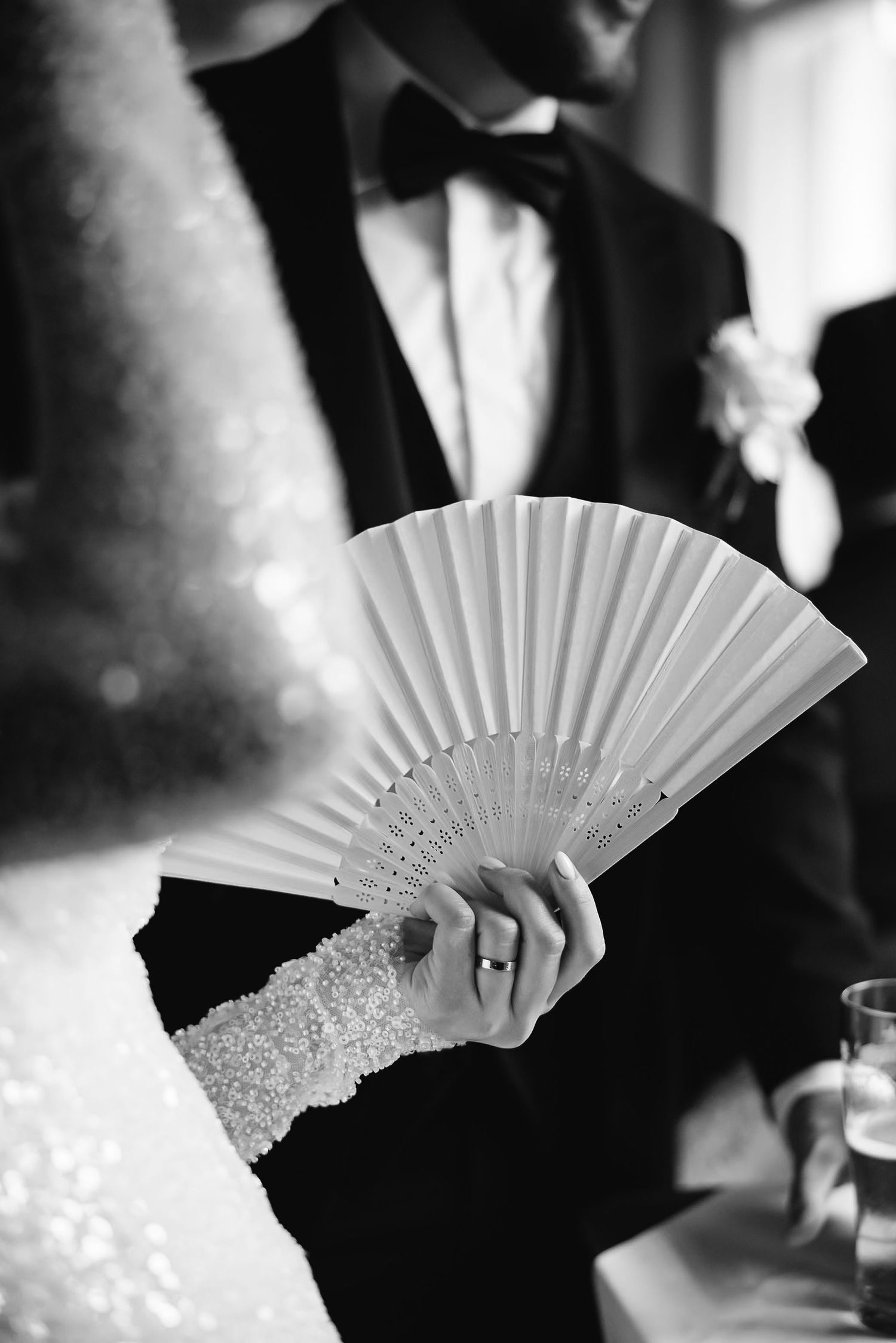 Close-up shots of decorative white lace fan being held during a formal event.