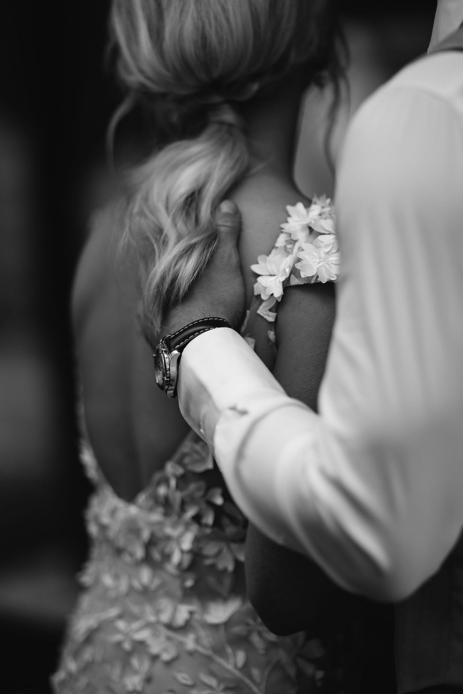 Close-up details of white floral hair accessories and lace against a black background.