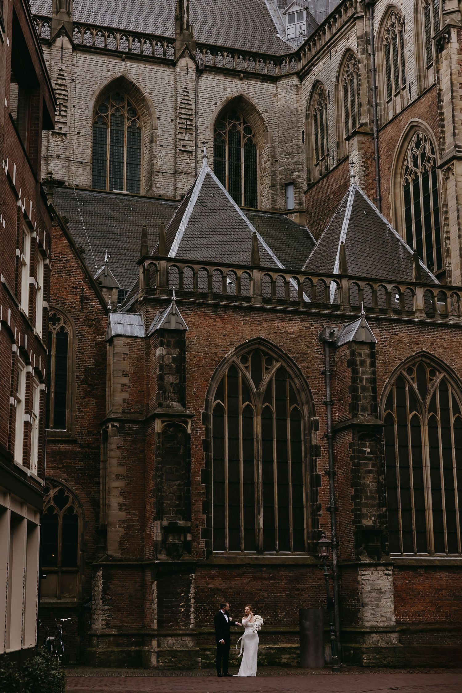 Gothic church architecture with stone walls and intricate arched windows in a historic setting.