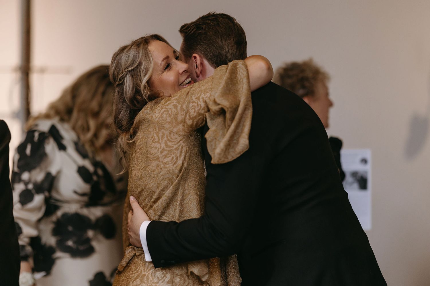 Intimate wedding couple embrace captured in warm indoor lighting.