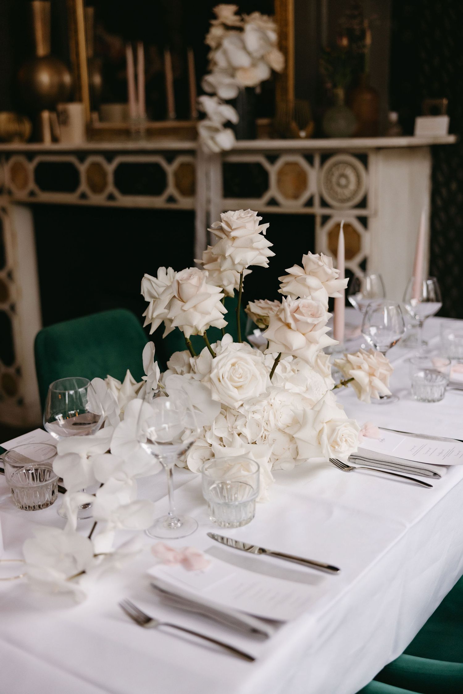 Elegant white floral centerpieces on crisp white tablecloths at a formal wedding reception.