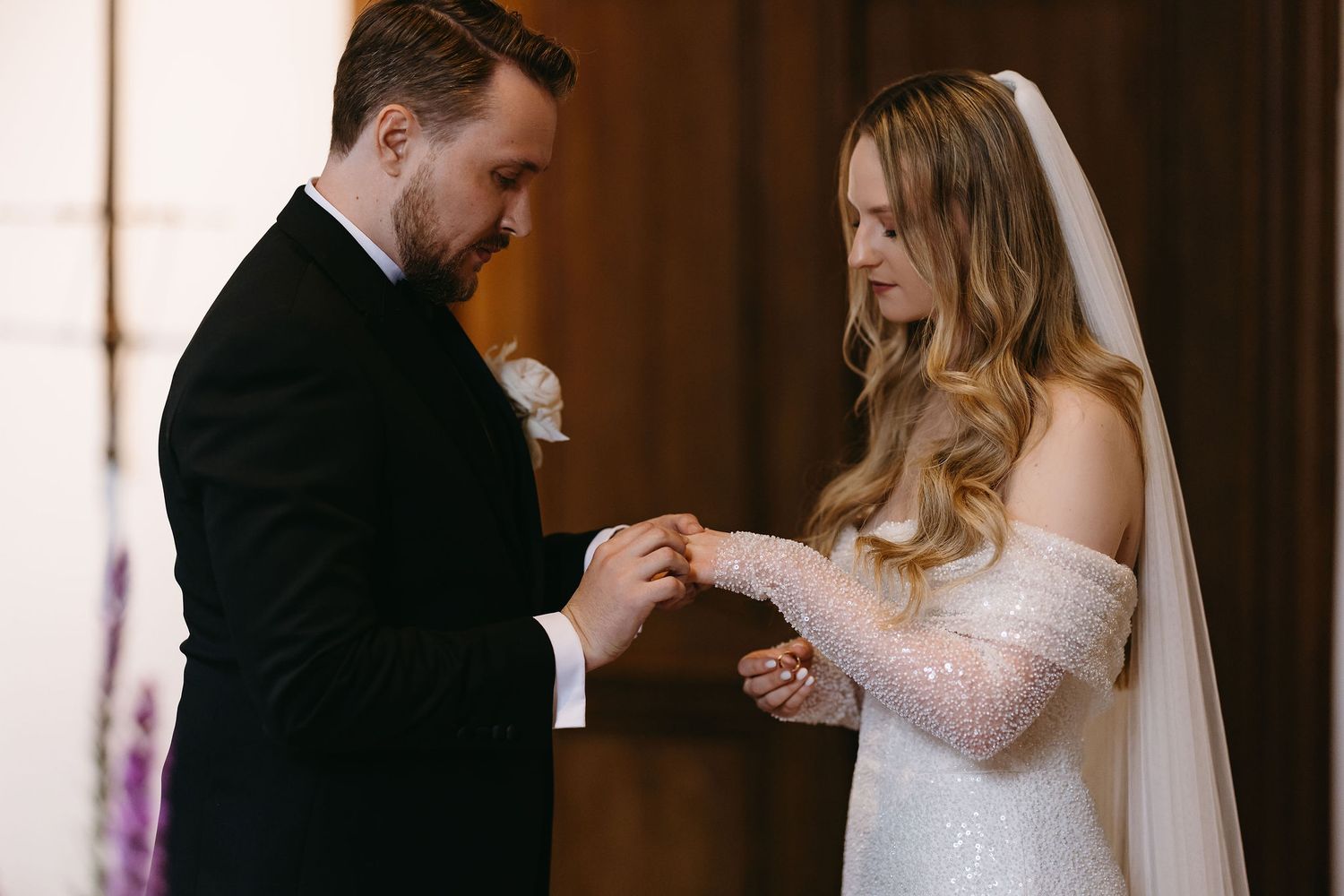 Intimate moment during wedding ring exchange ceremony.