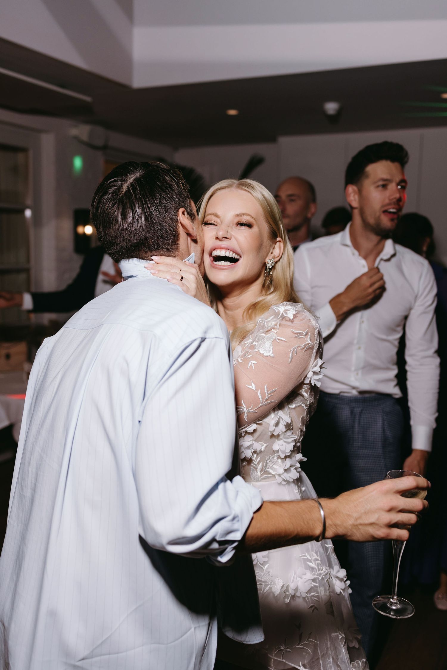 Wedding reception dance floor filled with joyful guests celebrating in formal attire.