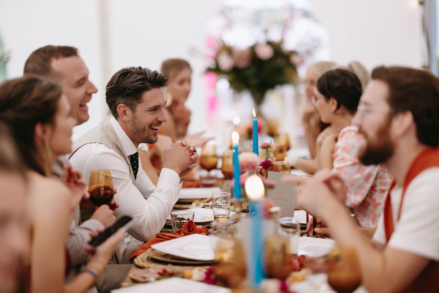 Wedding guests enjoying conversation around a decorated dining table.