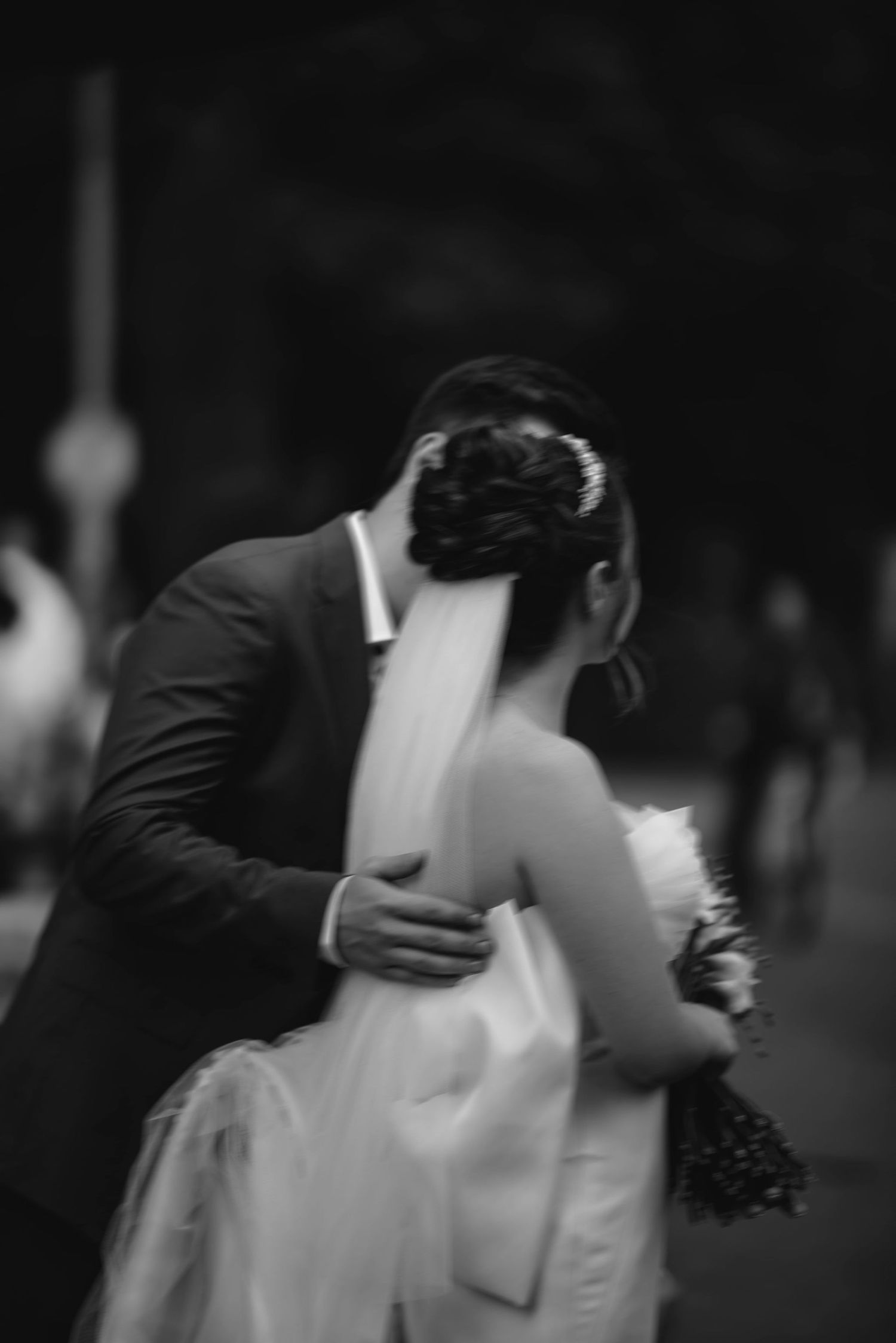 A romantic black and white wedding photograph showing a couple embracing on their special day.