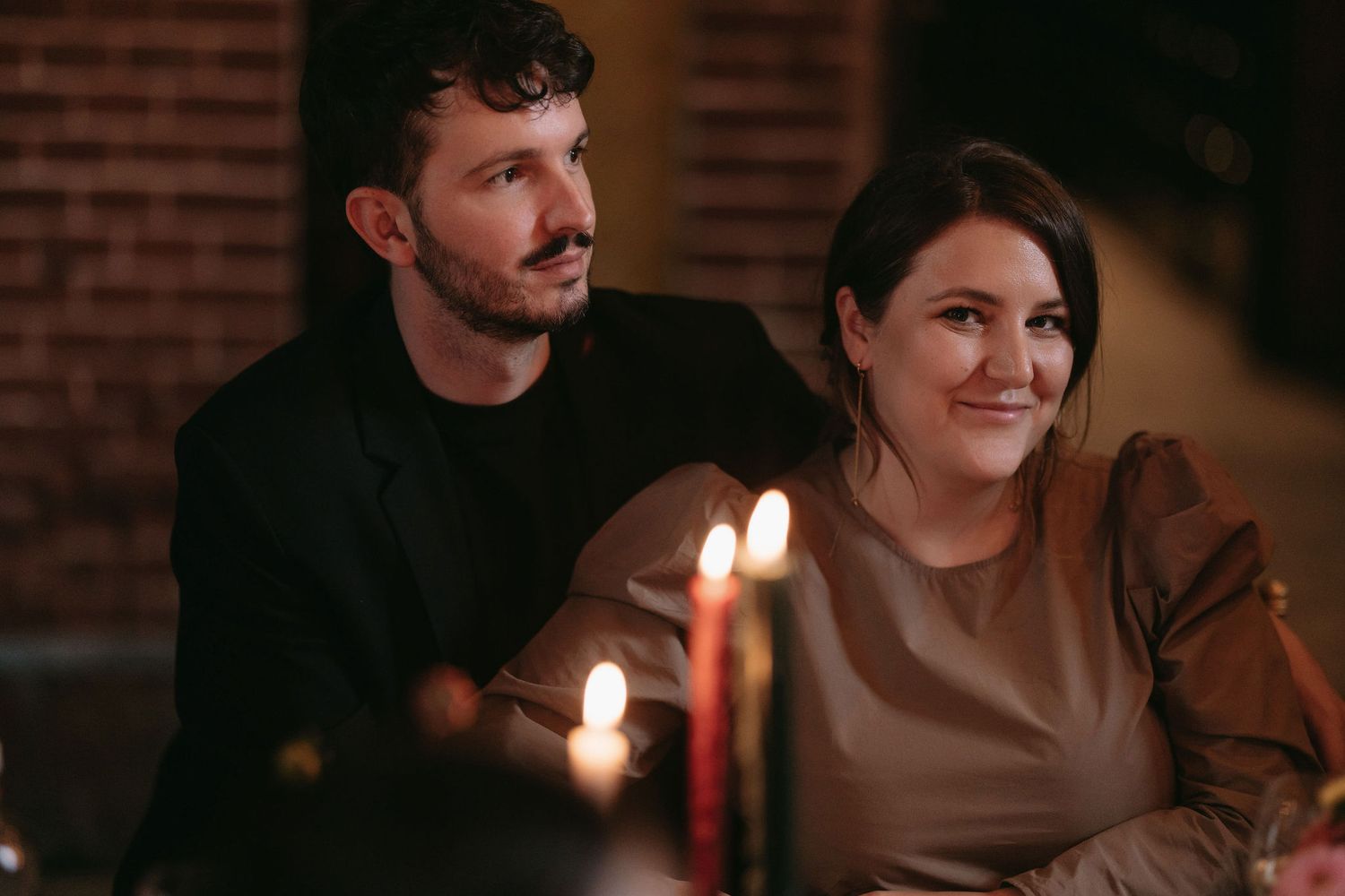 Couple enjoys intimate candlelit moment during evening celebration.