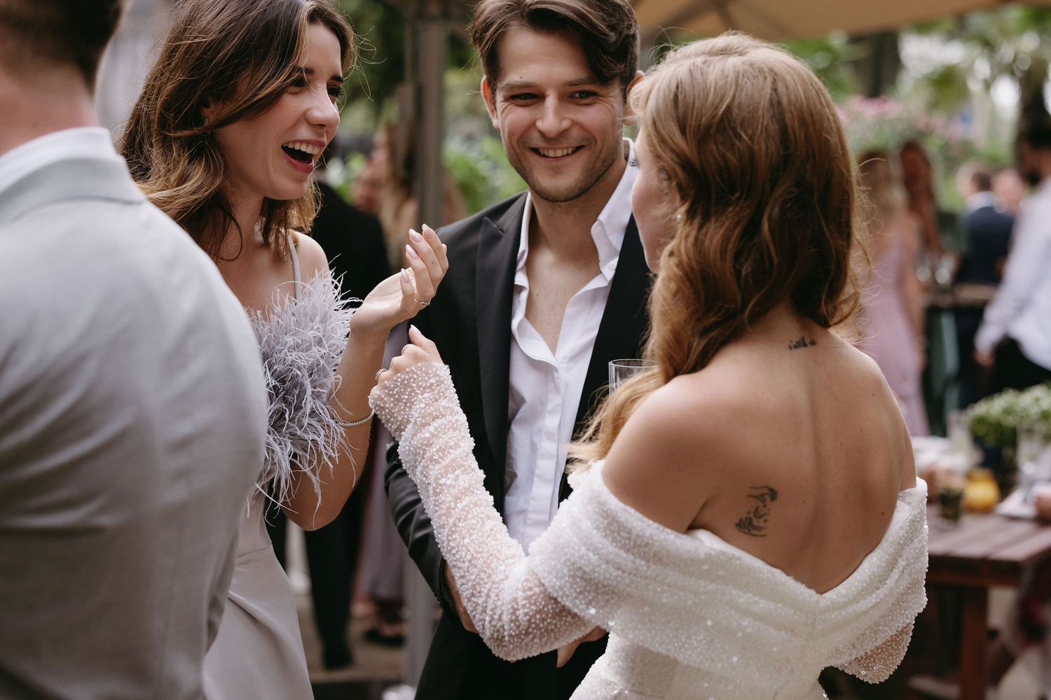 Wedding guests sharing laughs and conversation during an outdoor celebration.