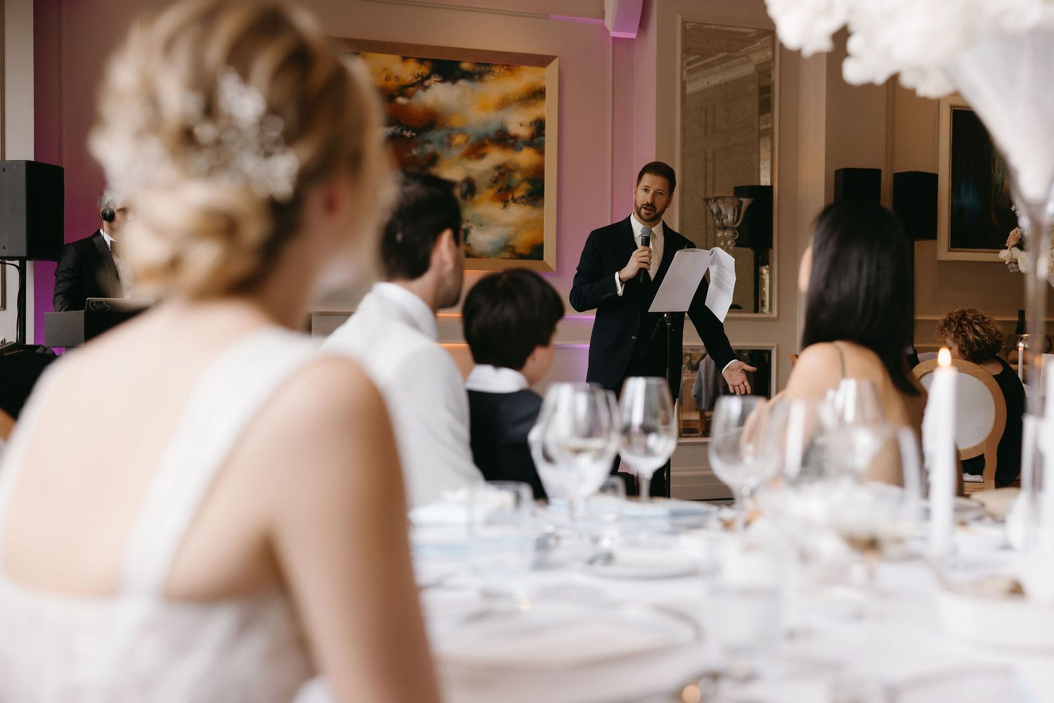 Elegant wedding reception table settings with soft focus and white decor elements.
