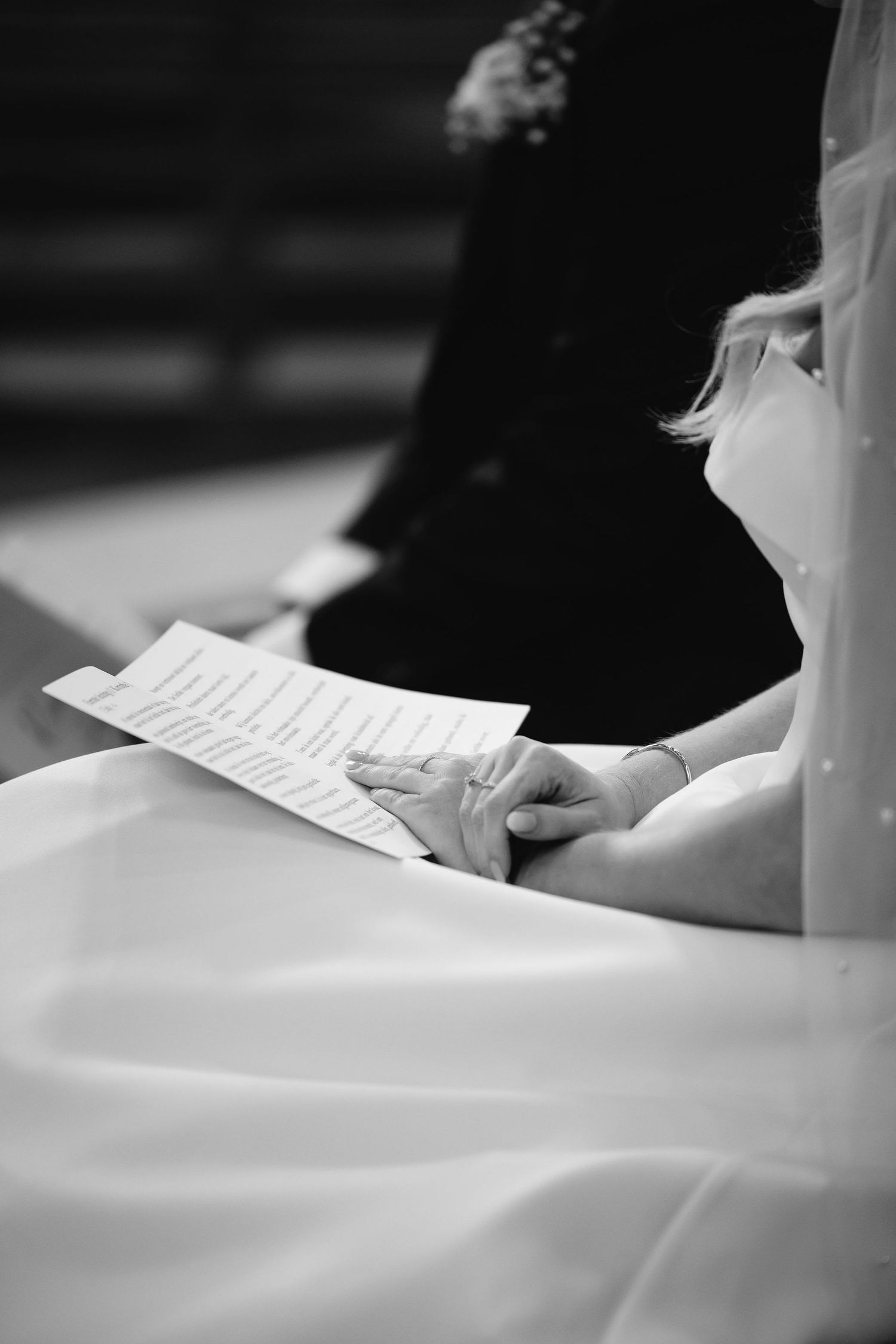 Black and white image of papers being held at a formal ceremony.