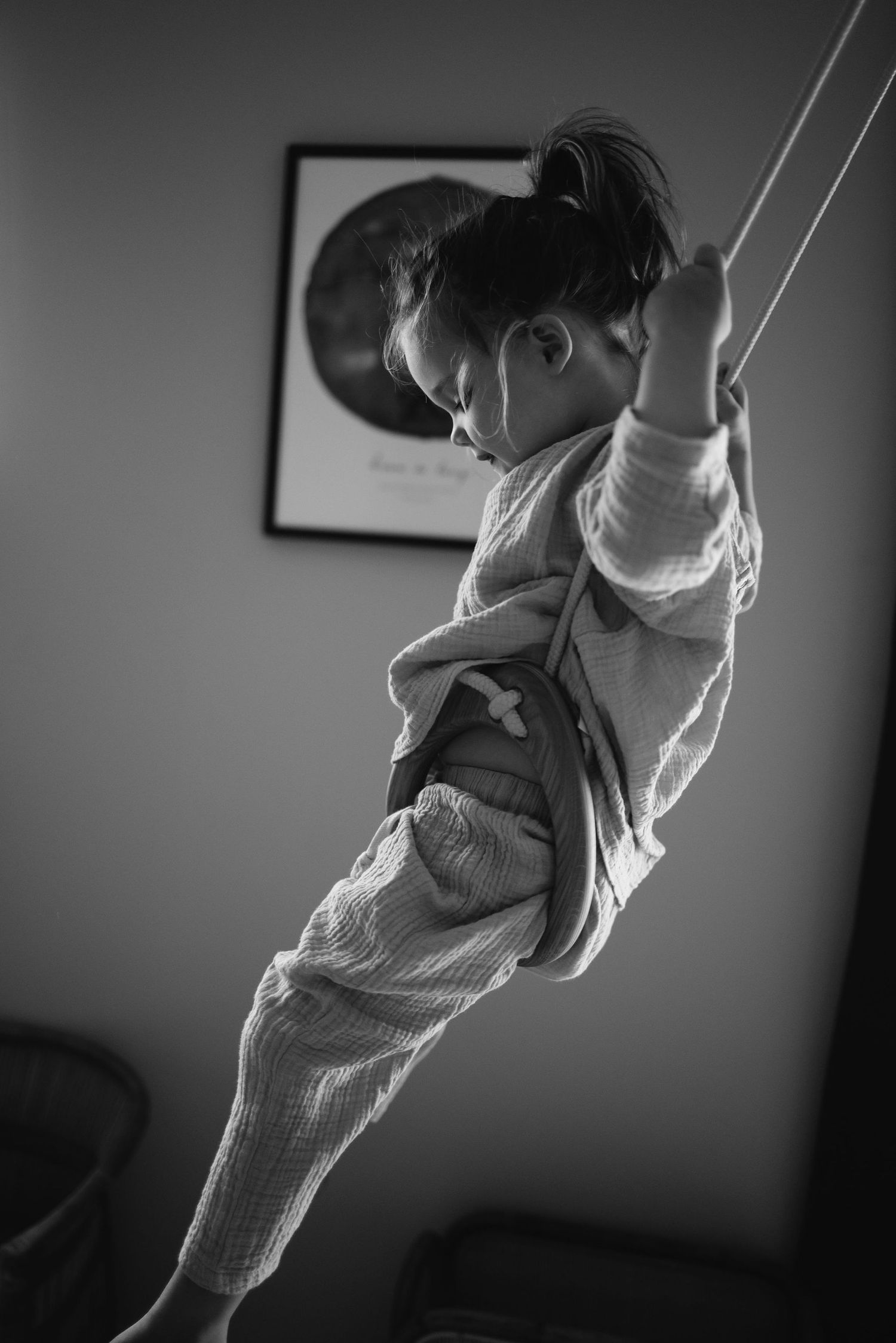 Black and white sequence of someone swinging in casual clothing against a dark background.