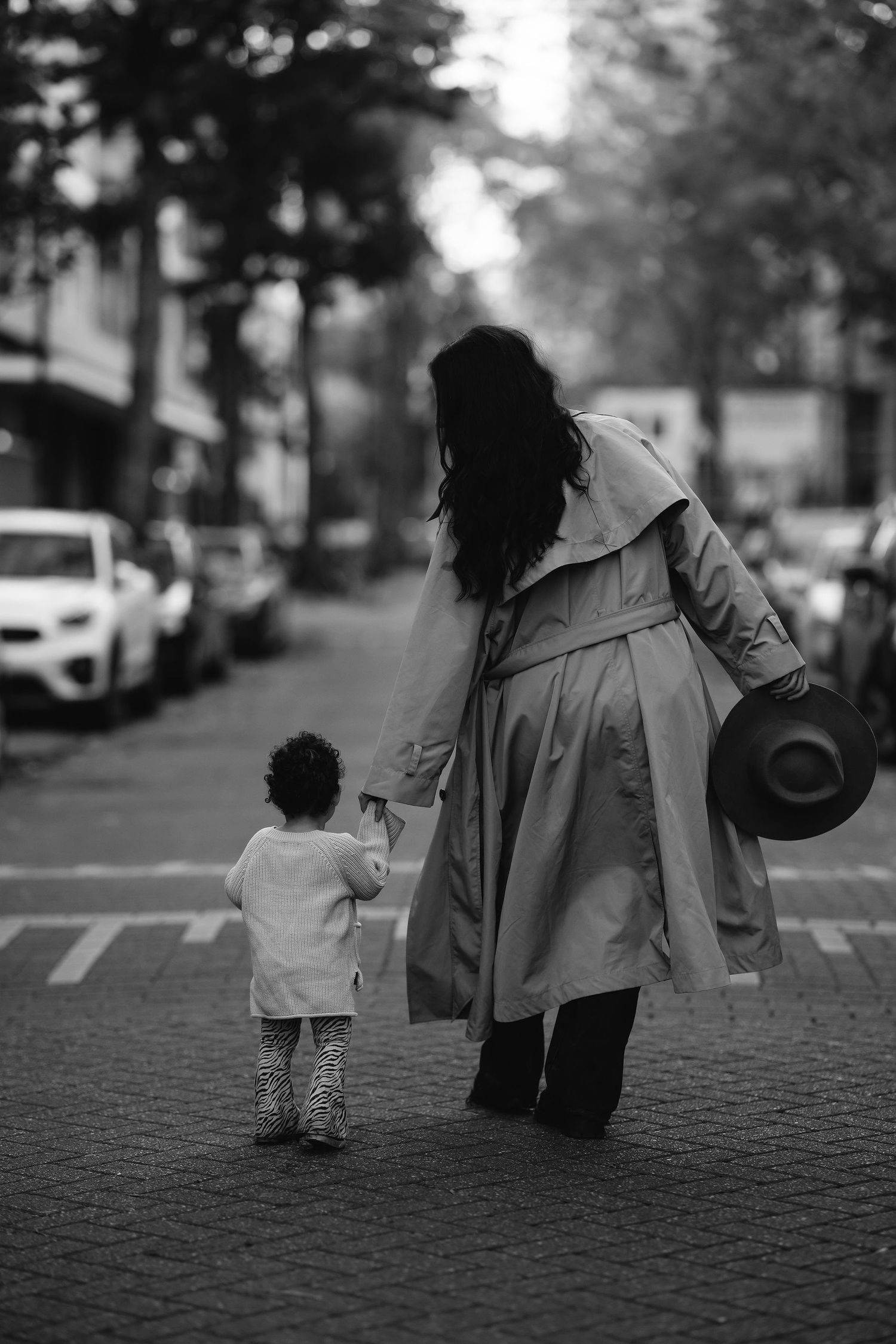 A black and white photo sequence showing figures walking together on a cobblestone street as they become increasingly blurry.