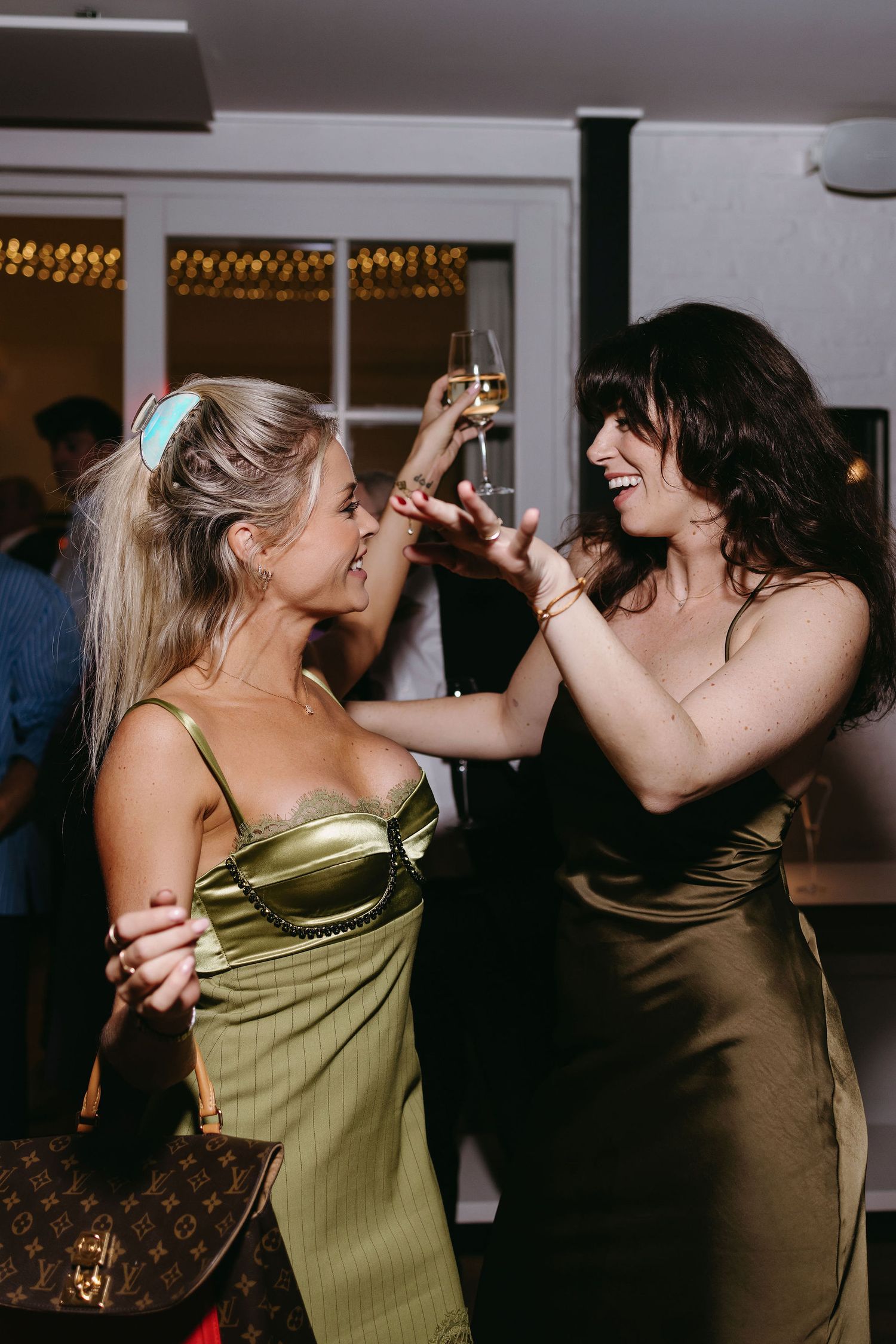 Friends dancing and celebrating with drinks at a party.