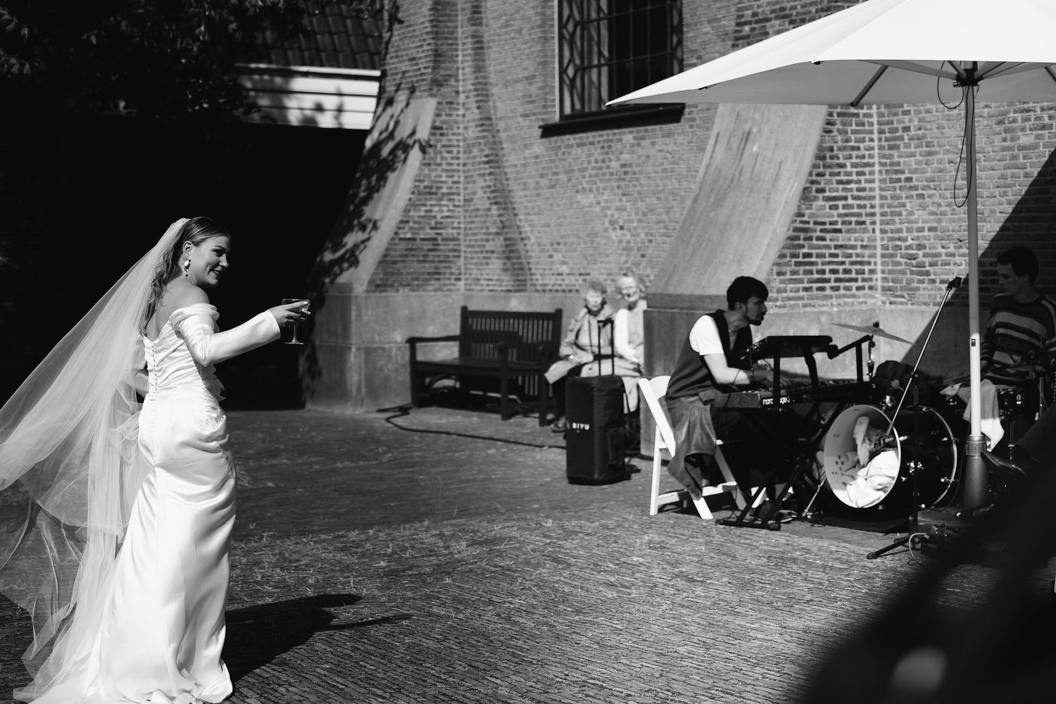A bride dances outside while a band performs at an outdoor wedding reception.