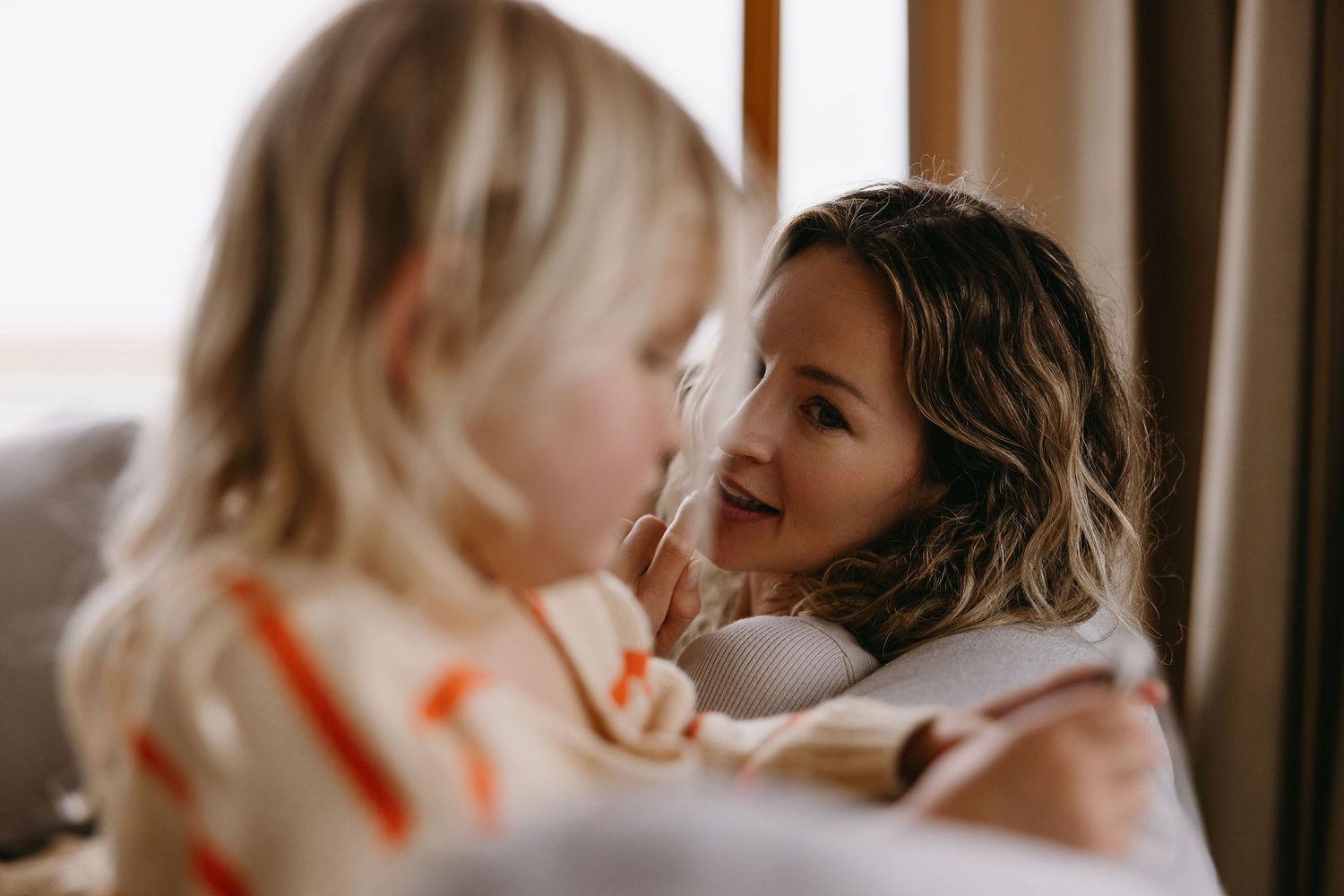 Two children sharing a playful and intimate moment on a comfortable couch.