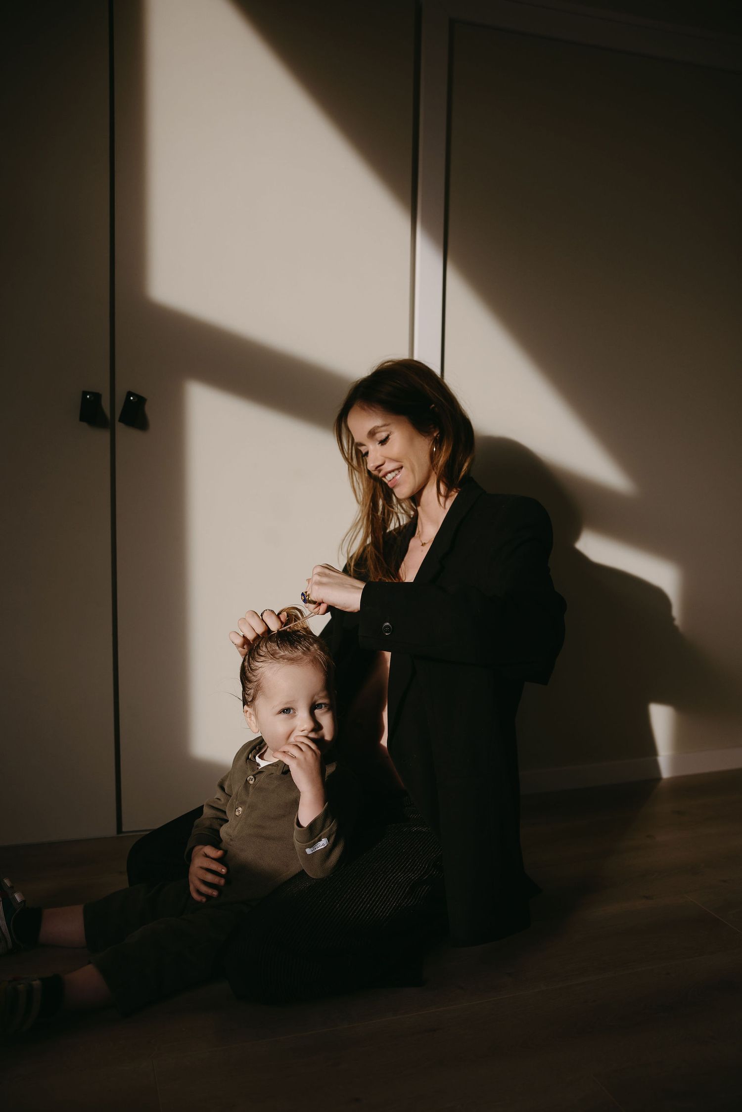 Intimate family moment captured in dramatic lighting with mother and child.