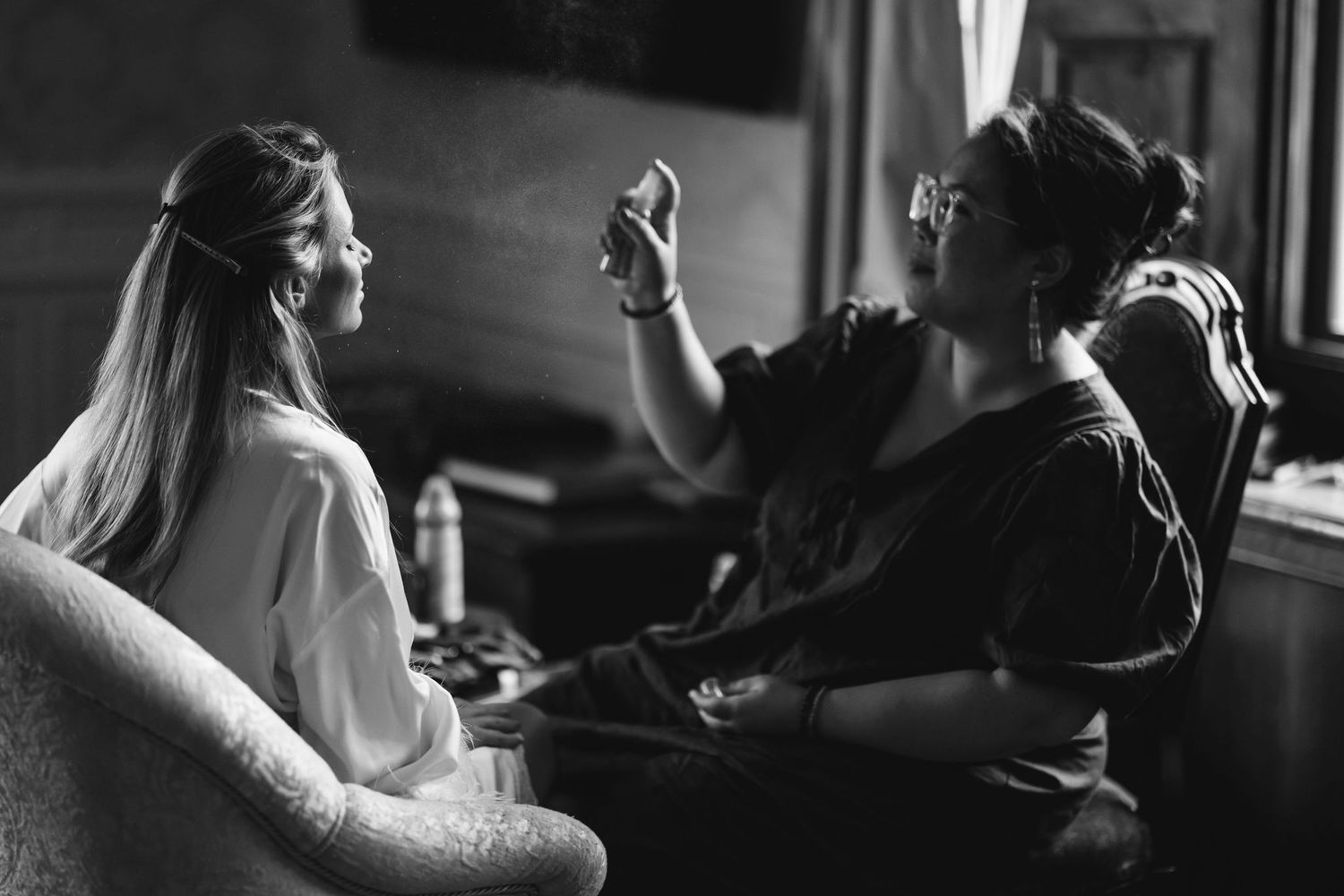 Two people having an animated conversation in a dimly lit room.