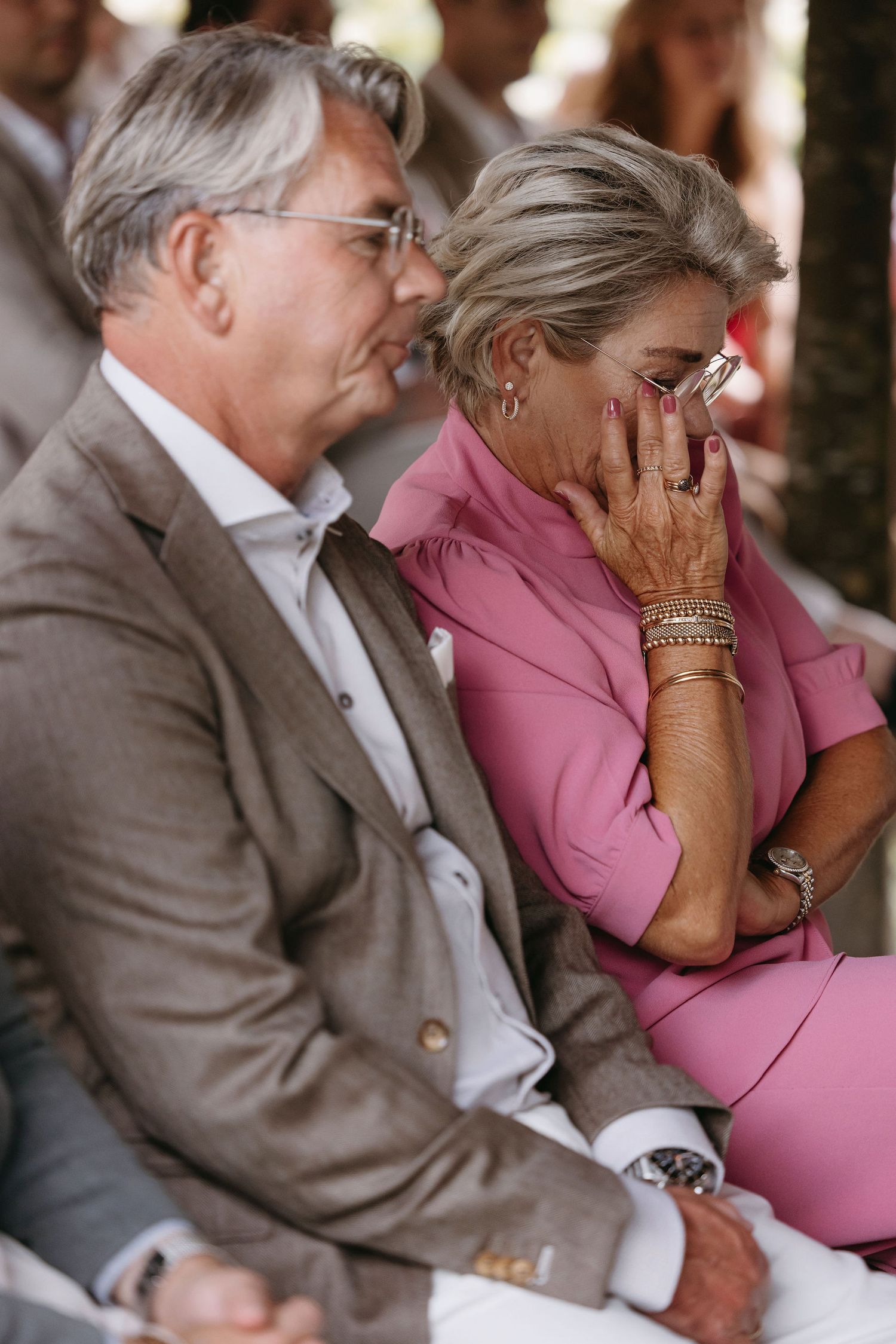Emotional moment captured of couple in formal attire seated during ceremony.