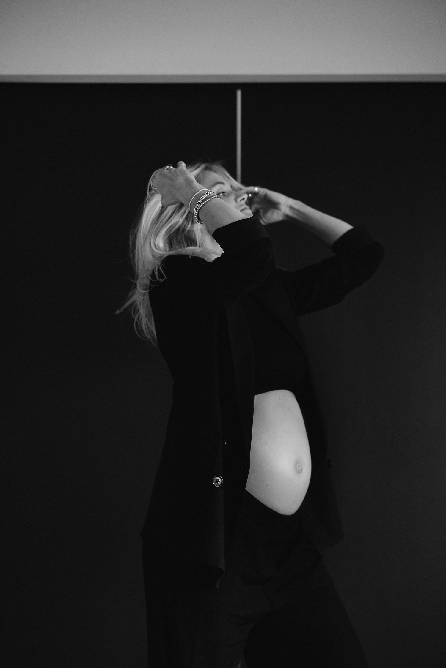 Artistic black and white photo showing a dramatic pose against a dark background.