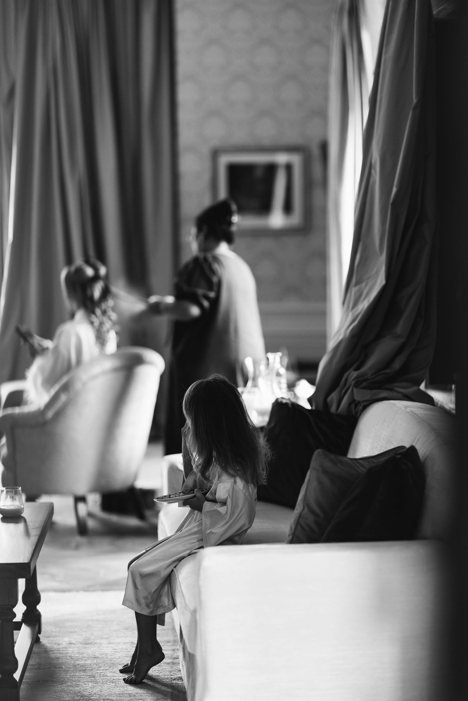 Black and white candid photo of people relaxing in an elegant lounge setting.