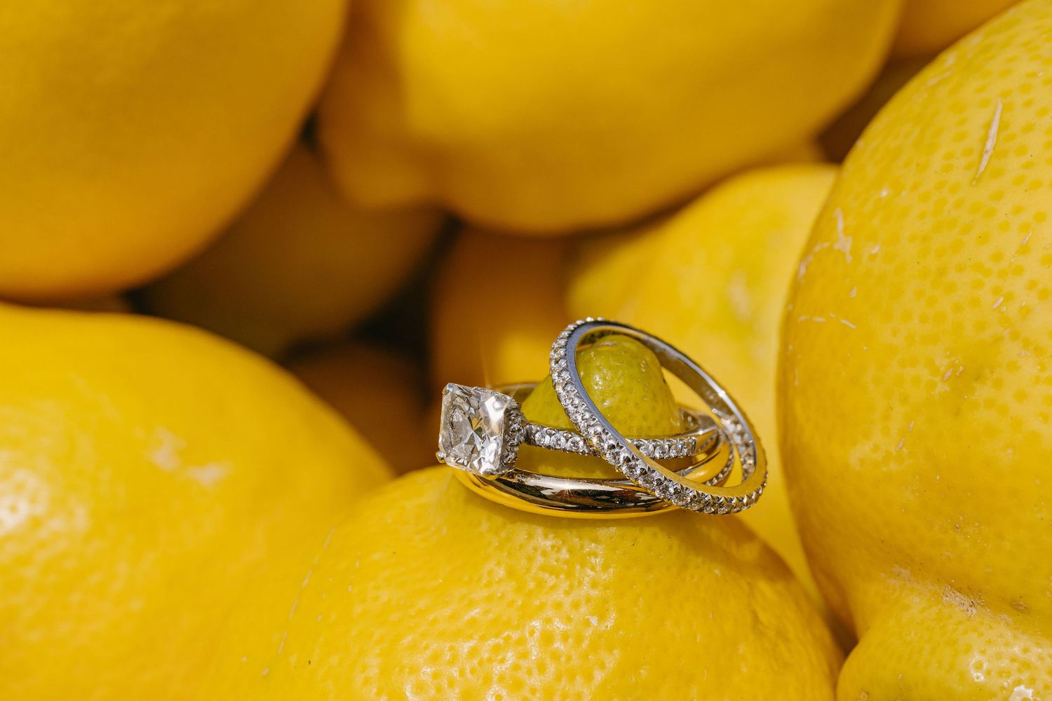 Wedding rings displayed creatively on fresh yellow lemons.