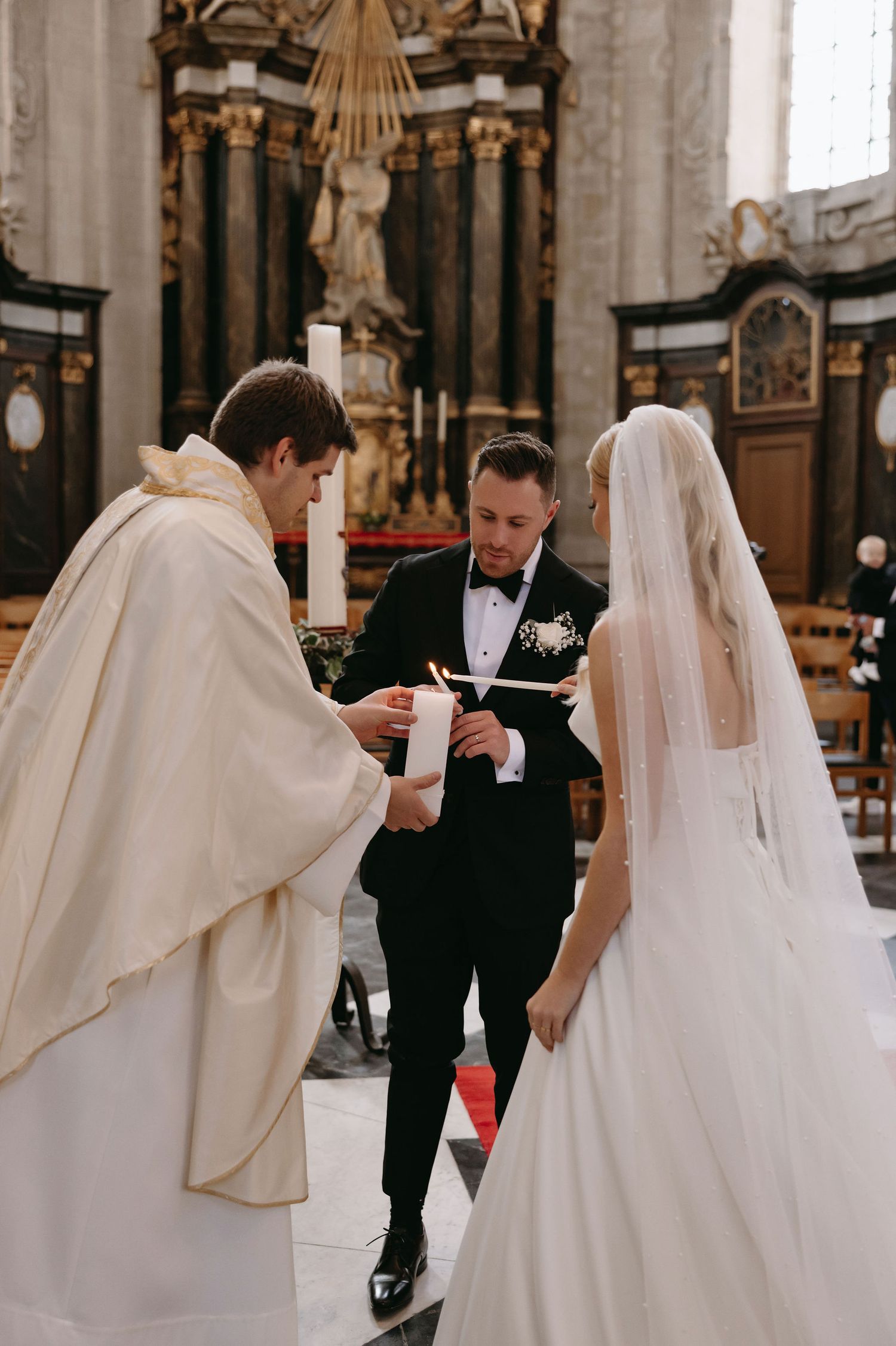 A traditional church wedding ceremony being performed by a priest in an ornate cathedral setting.