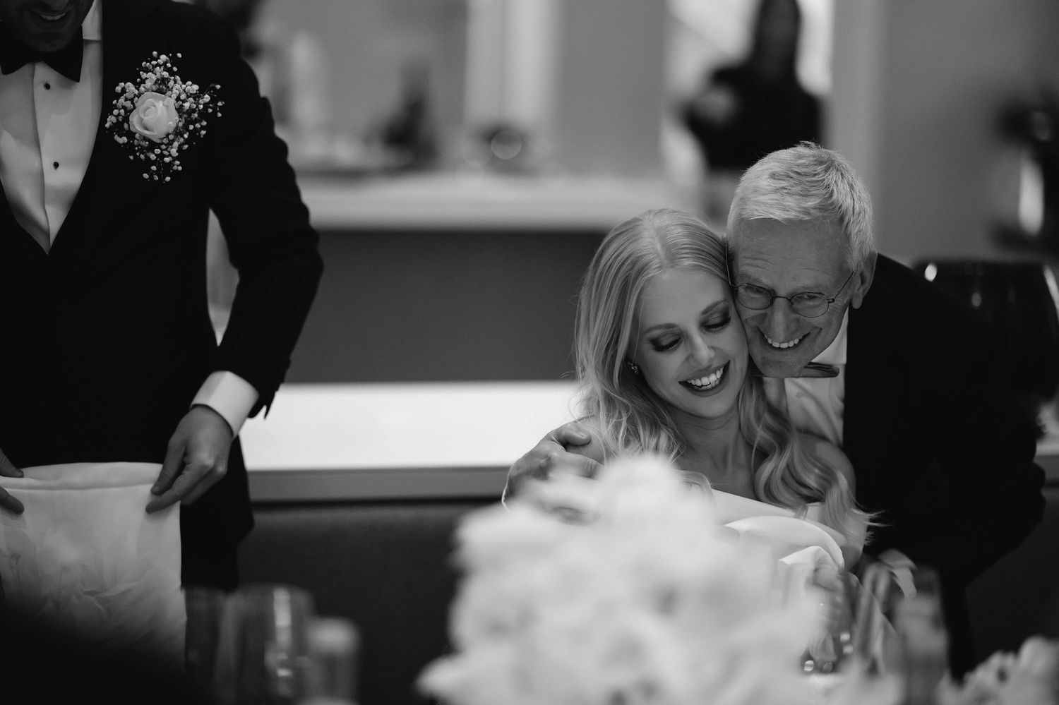 Black and white candid moment captured during an elegant wedding reception.
