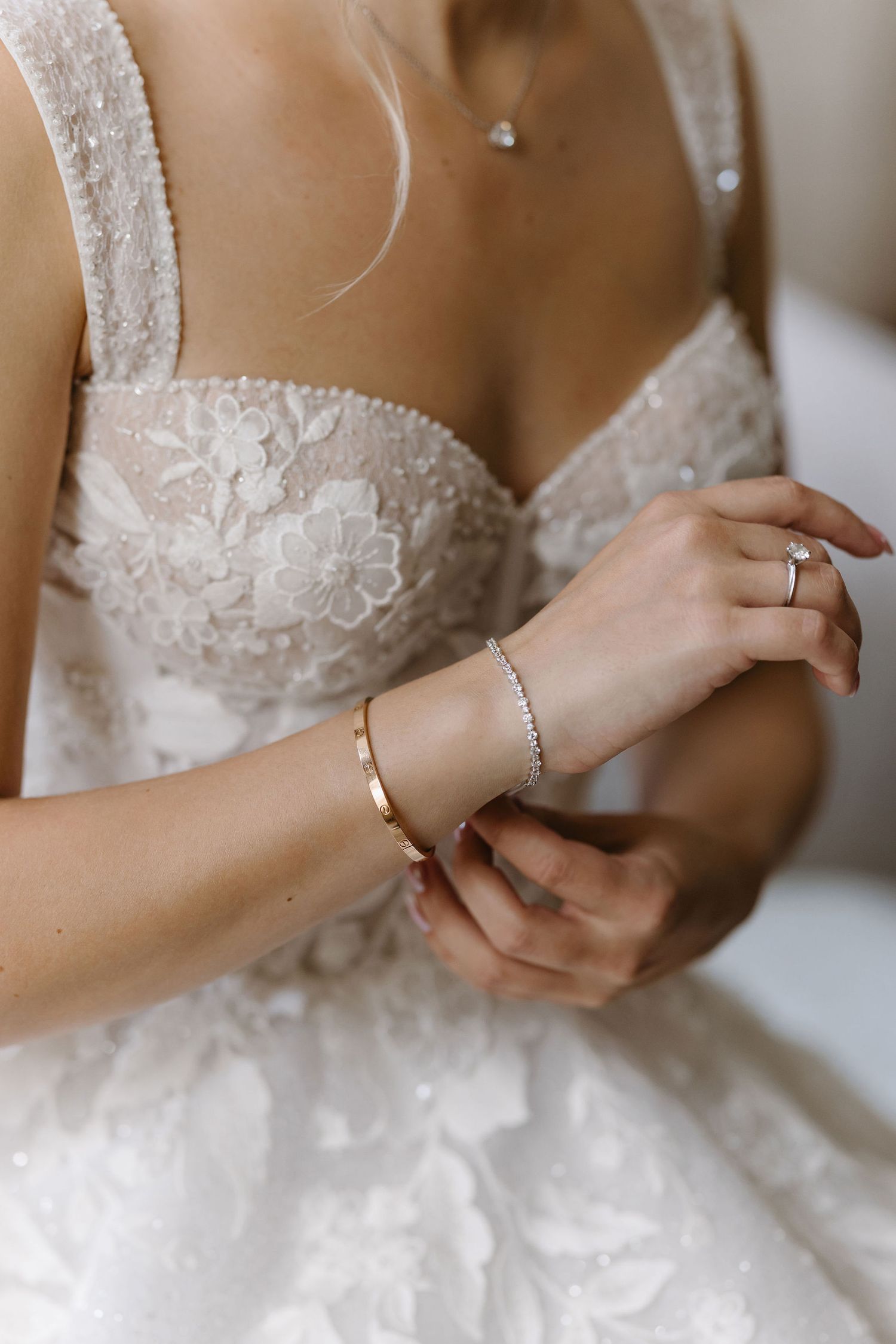 Close-up details of wedding dress showing intricate beadwork and lace straps.