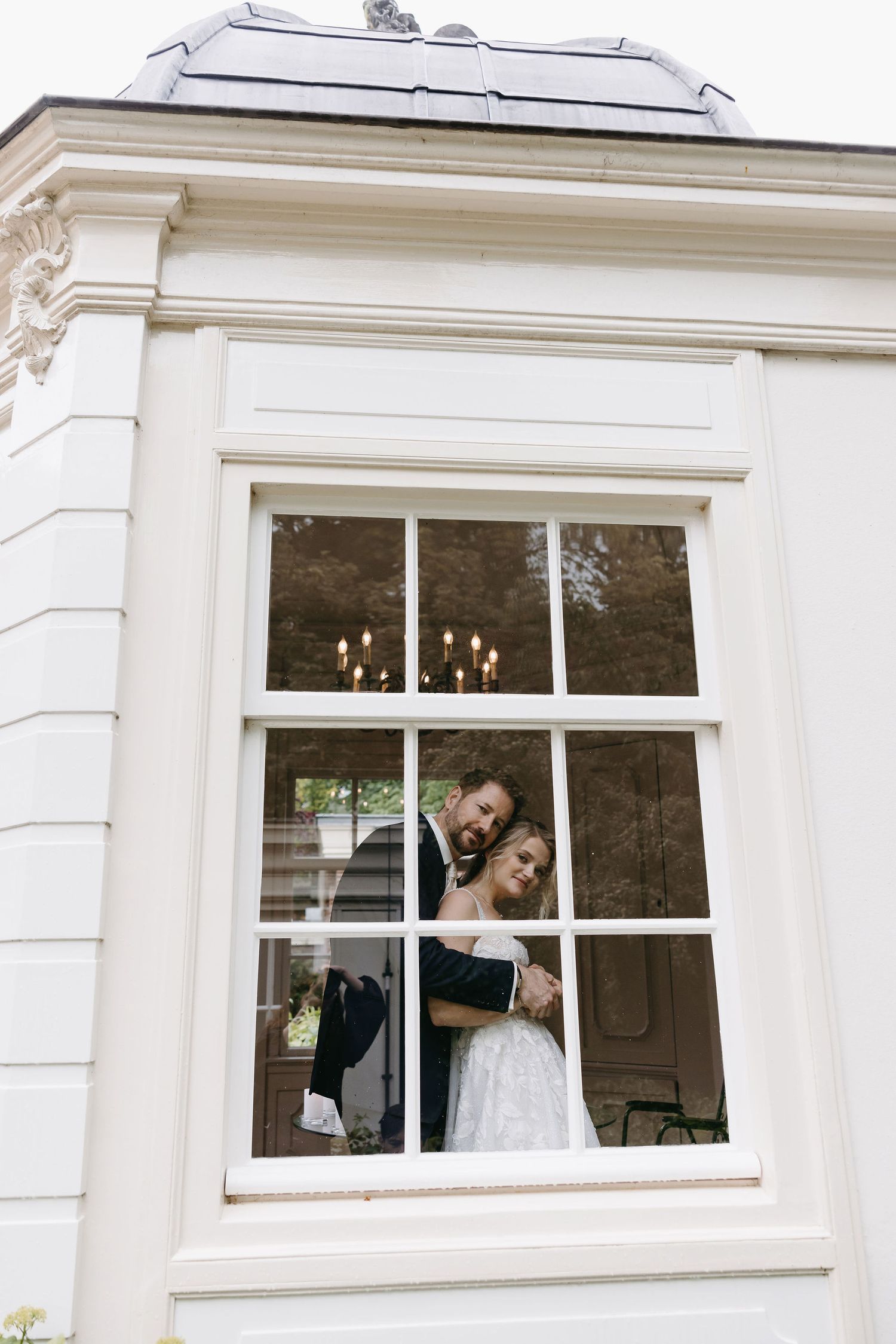 Classic white building exterior with architectural details and framed windows.