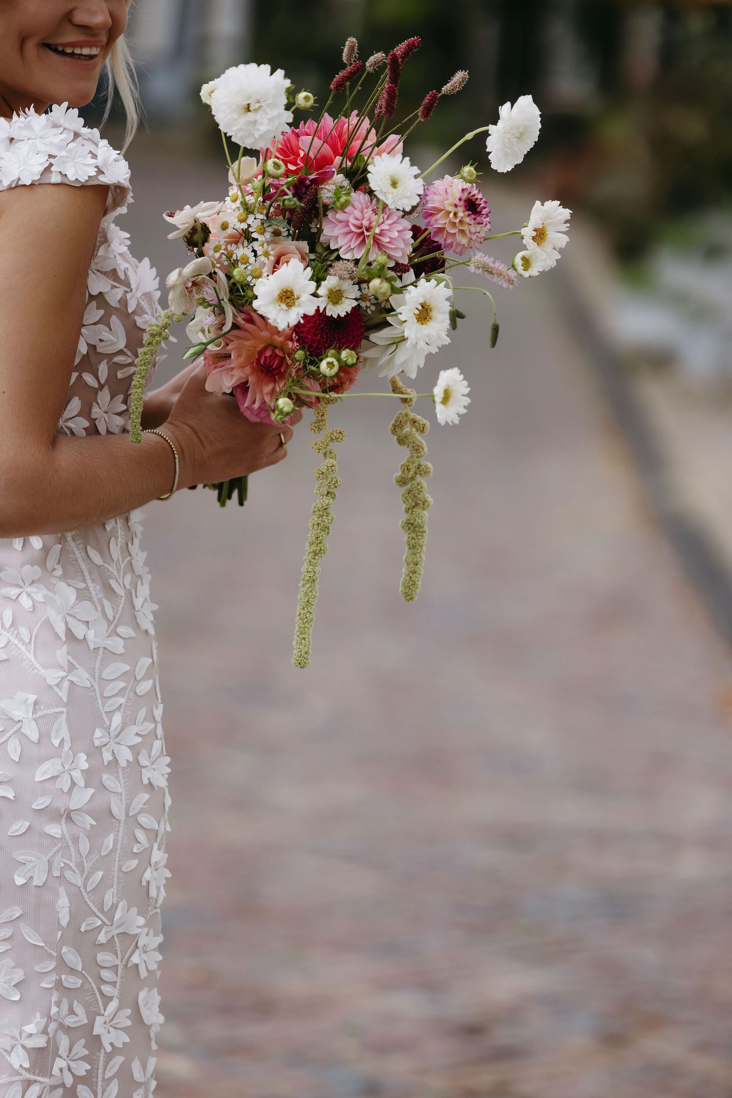 Close-up of white and pink floral wedding bouquets with trailing greenery.