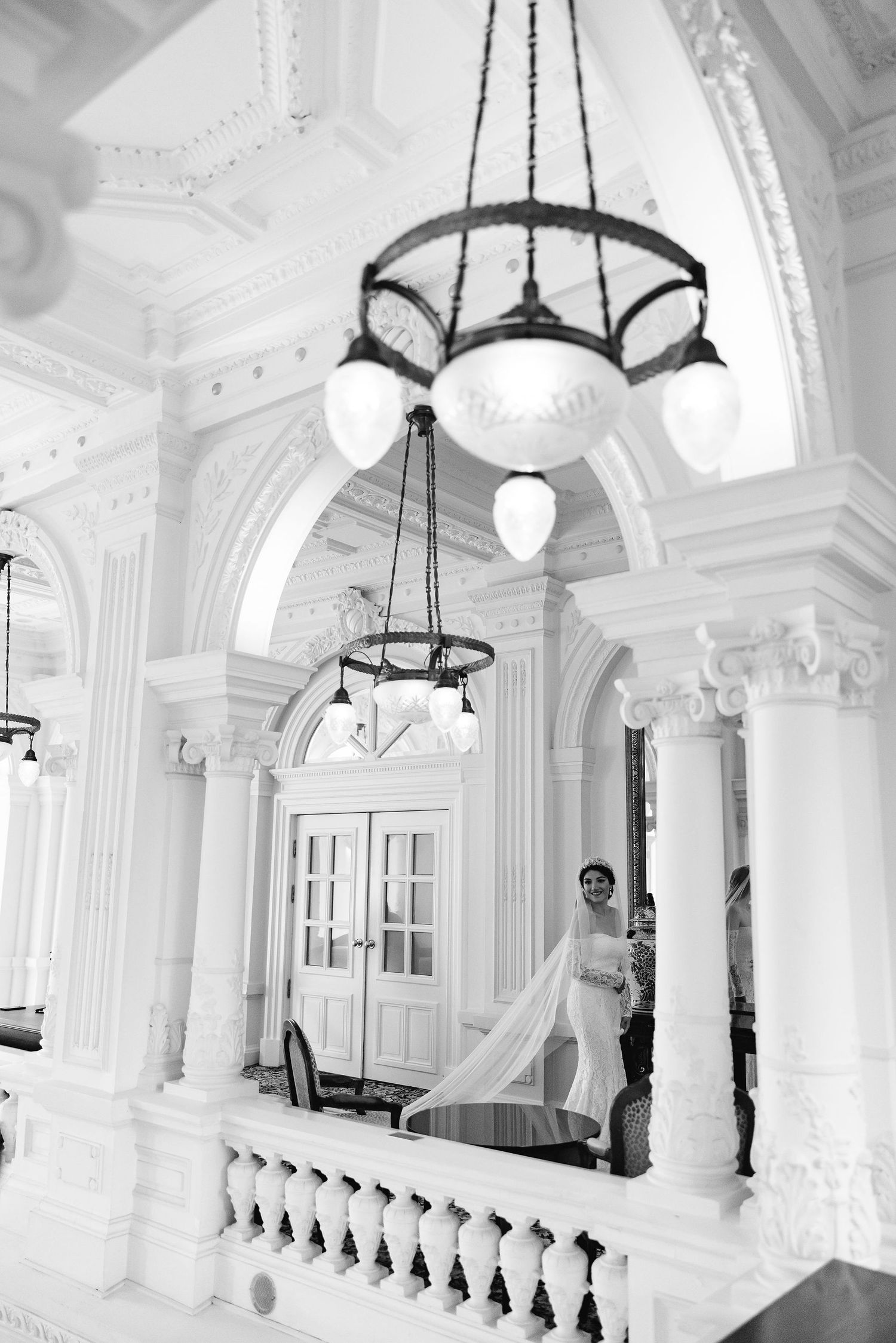 A dramatic black and white photo of a cathedral interior with ornate chandeliers and classical architecture.
