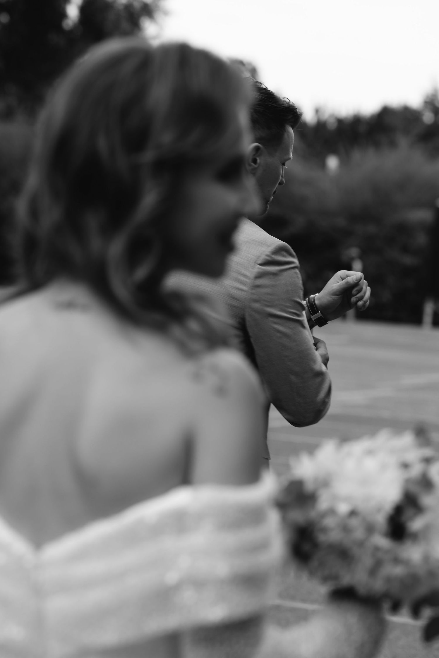 Artistic black and white shot of newlyweds in an intimate outdoor moment.