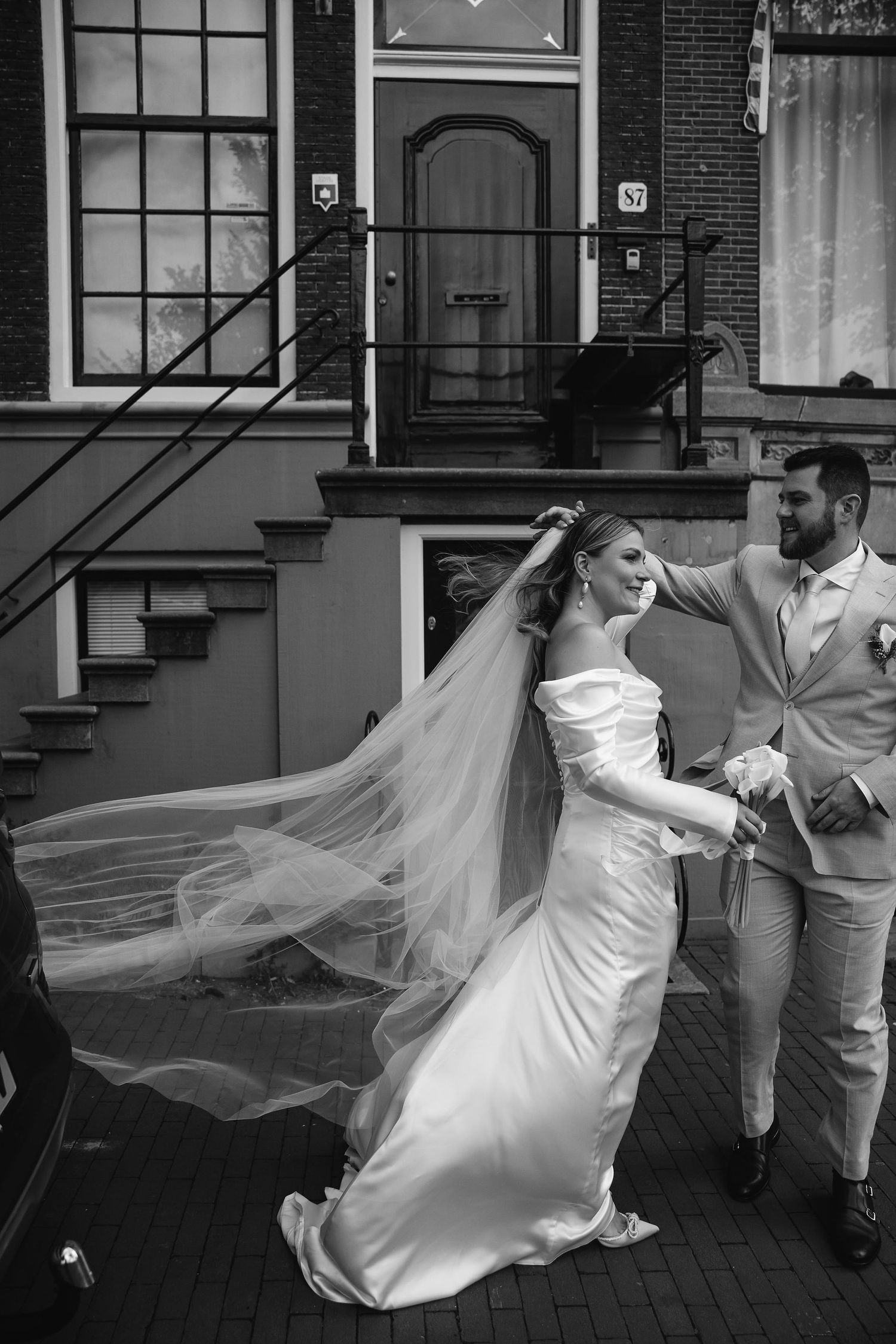 Black and white series capturing movement of a bride's flowing dress and veil outdoors.