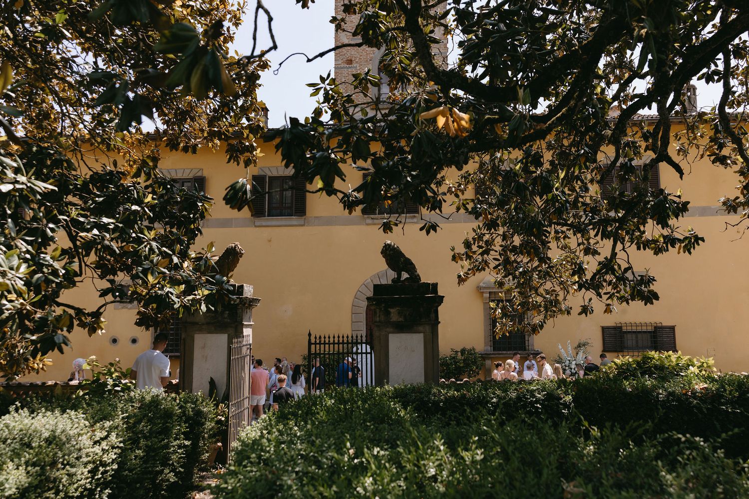 Exterior view of an Italian villa with garden landscaping during a wedding event.