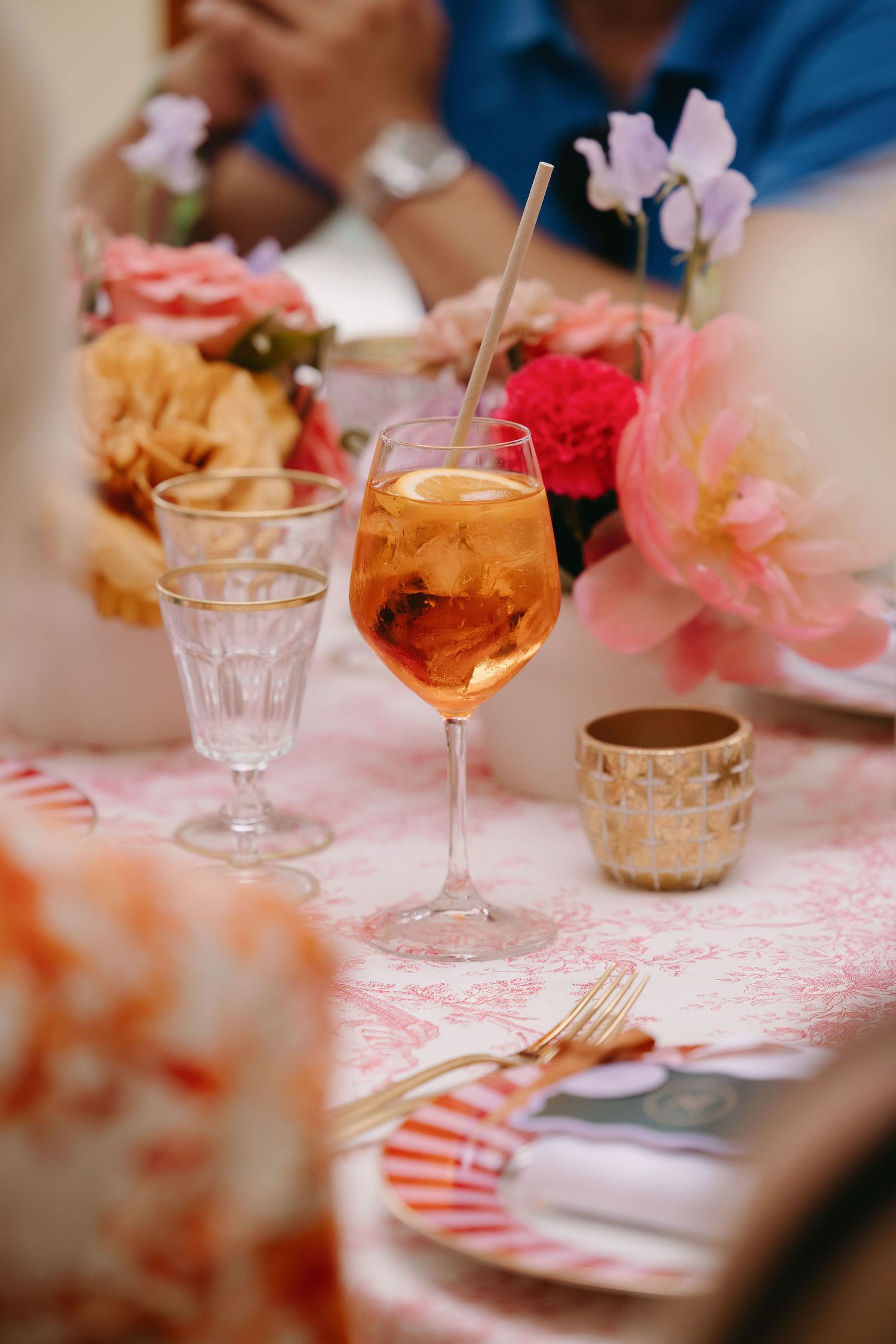 Table setting with pink details and wine glasses at an elegant wedding reception.