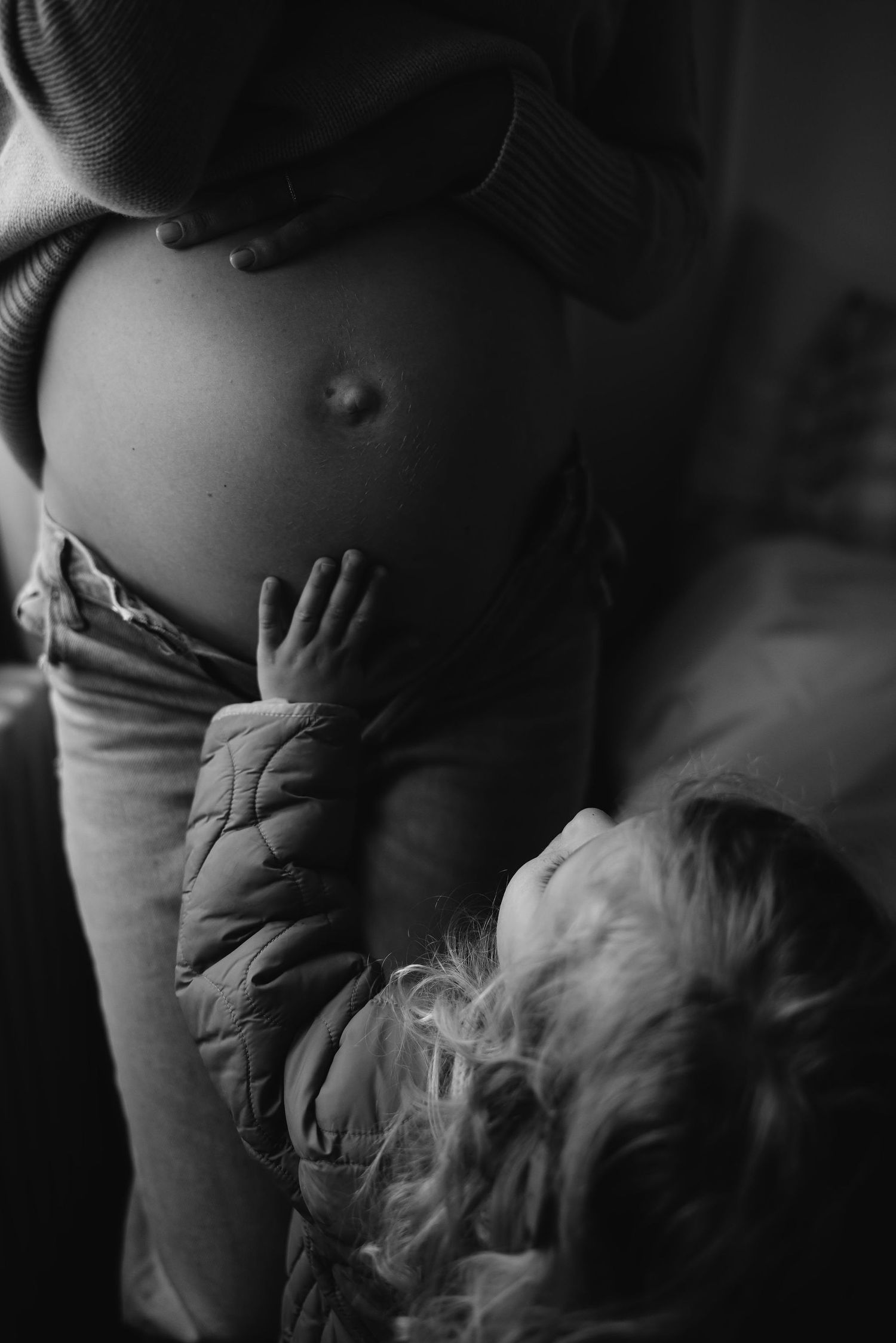 Intimate black and white maternity photos with dramatic lighting and shadows.