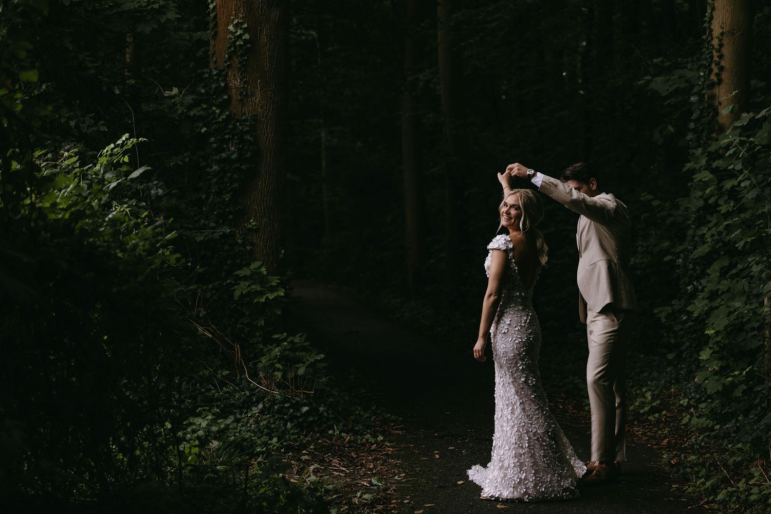 Artistic silhouette of newlyweds embracing in a wooded forest setting.