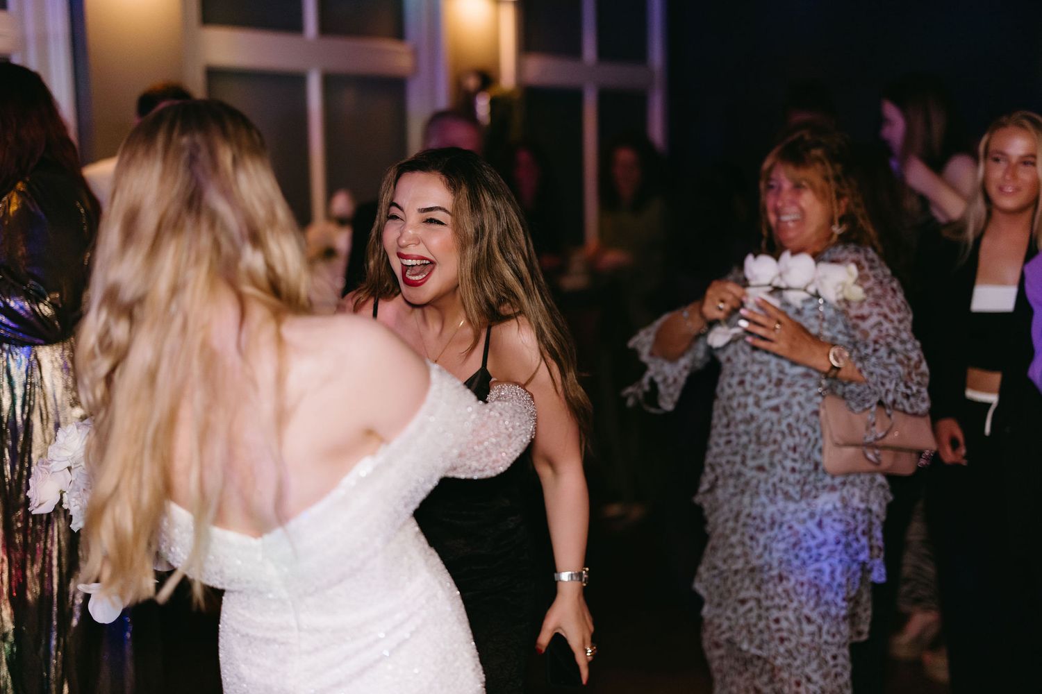 Dancing and celebration at a wedding reception with festive lighting.