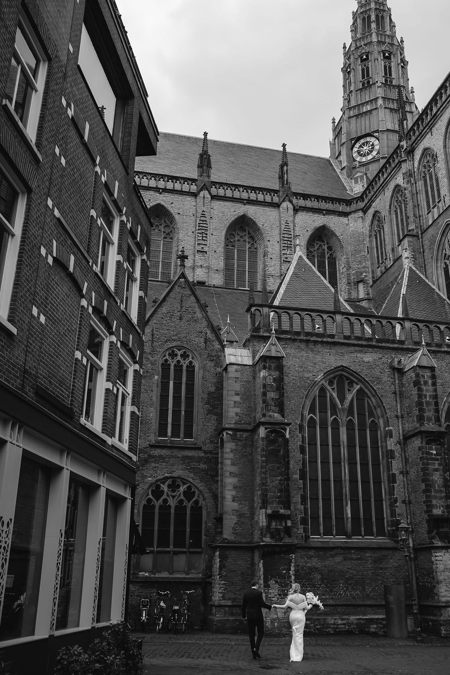 Black and white photo of gothic church architecture with cathedral spire and stone details.