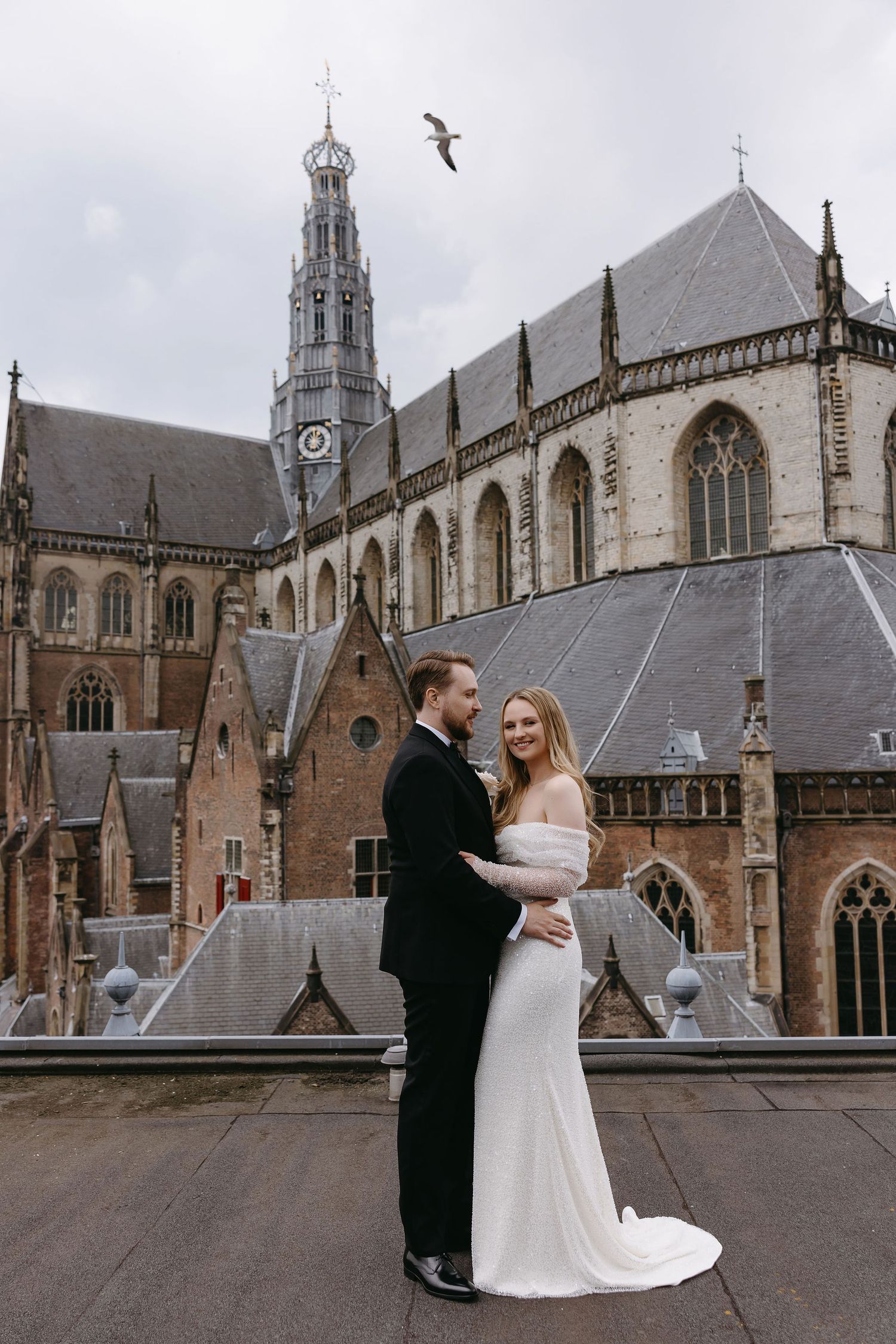 A wedding photoshoot outside a majestic Gothic church with architectural details.
