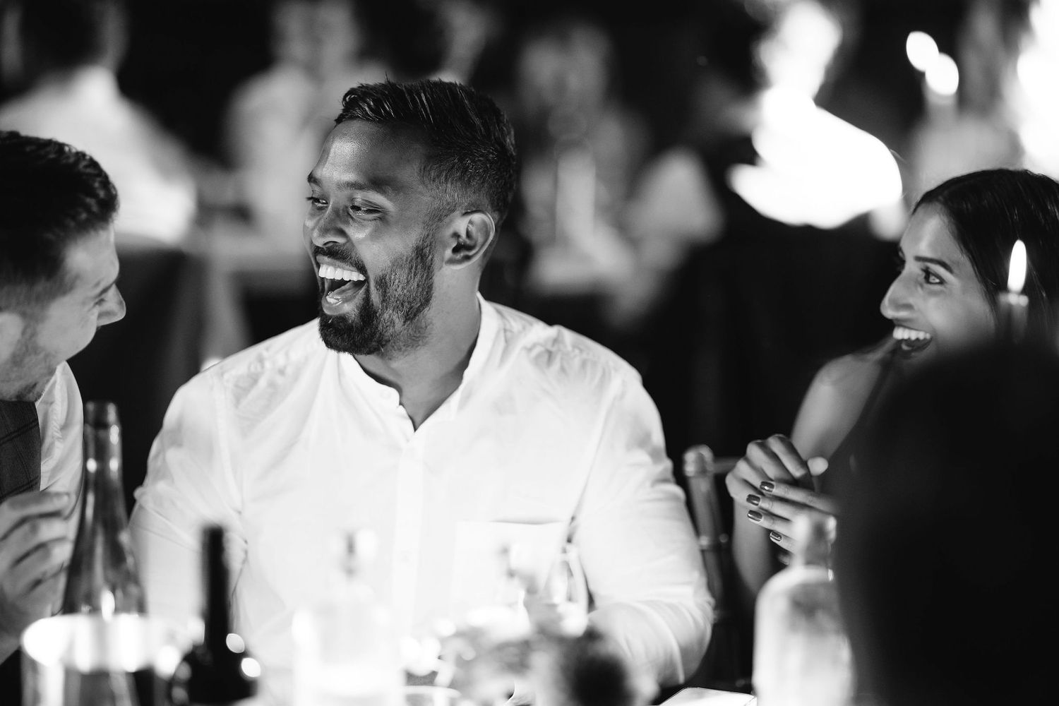 Black and white candid shots capture laughter and joy during wedding reception.