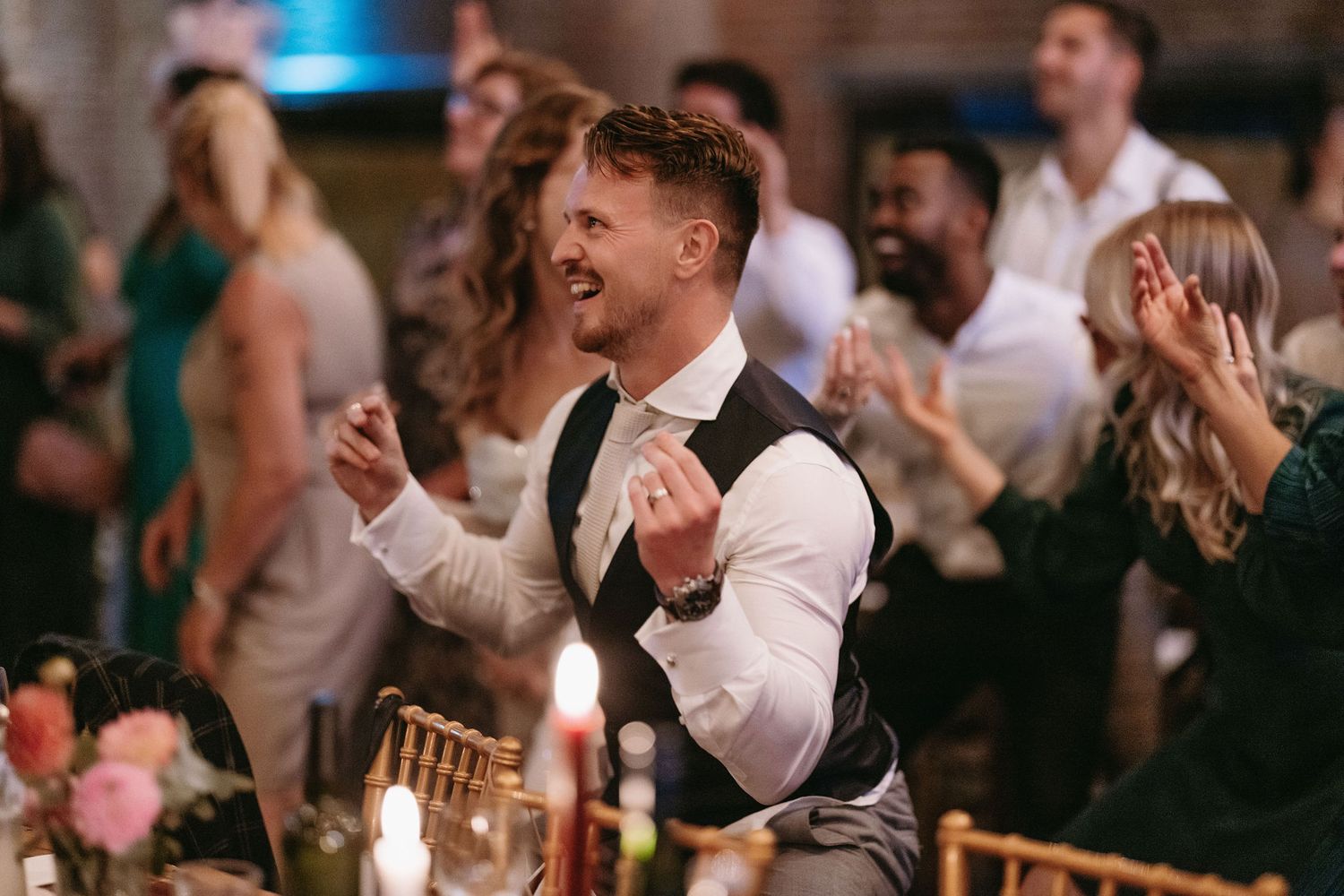 Guest enthusiastically dancing and celebrating at an elegant wedding reception.
