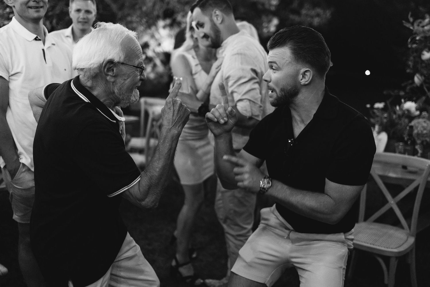 Wedding guests celebrating and dancing at an outdoor evening reception.