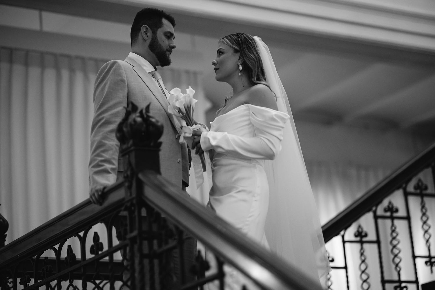 Black and white wedding moment captured in an elegant interior setting.