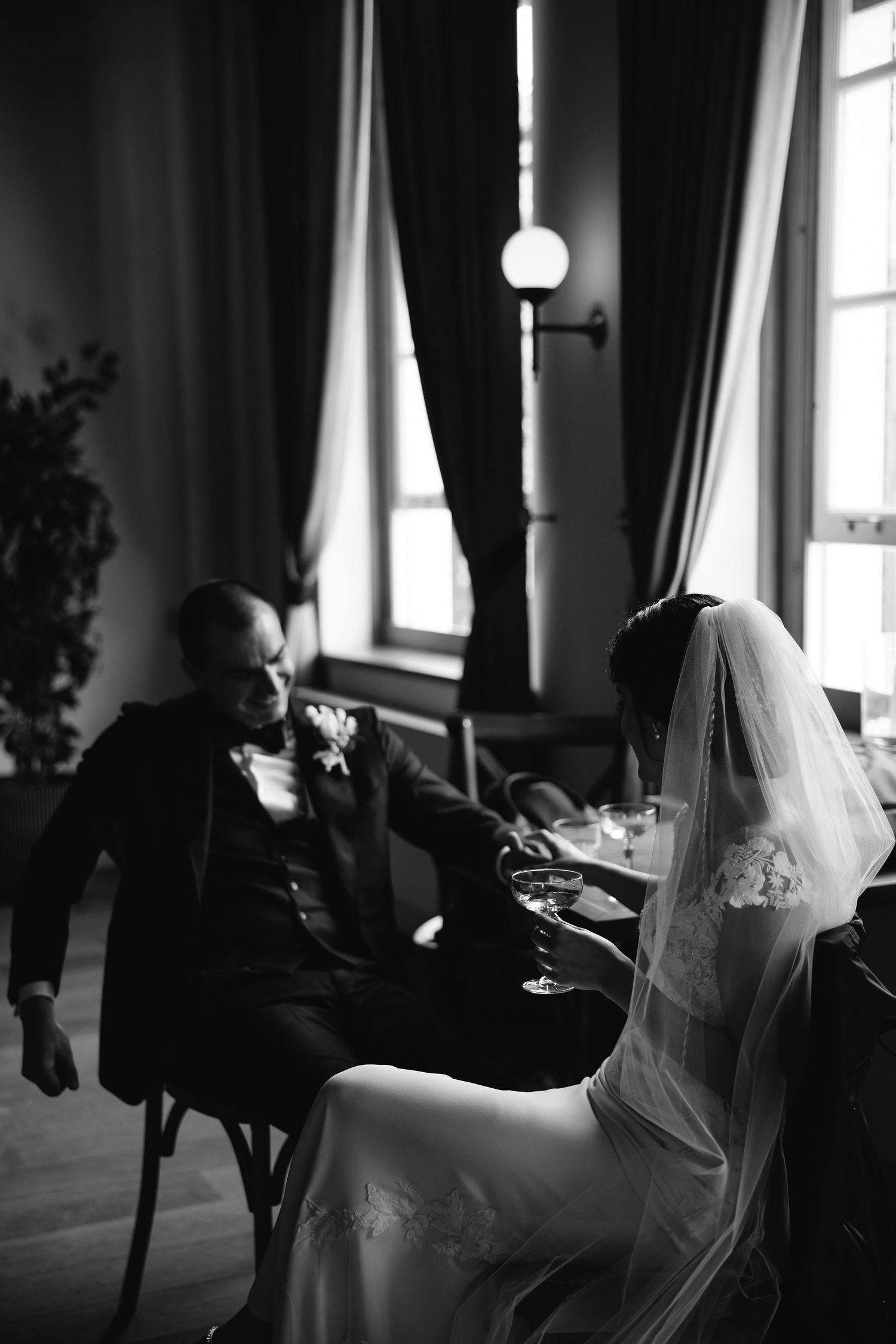 A black and white artistic photo series showing the bride and groom in an intimate setting by a window.